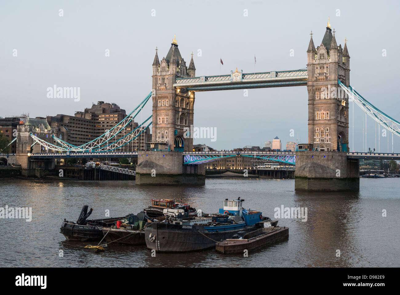 LONDON, Vereinigtes Königreich – Londons Tower Bridge am frühen Abend mit Binnenschiffen auf der Themse im Vordergrund. Die verzierte Tower Bridge wurde Ende der 1800er Jahre erbaut und ist eines der Wahrzeichen Londons. Seinen Namen erhielt er vom nahegelegenen Tower of London am nördlichen Ufer der Themse. Stockfoto