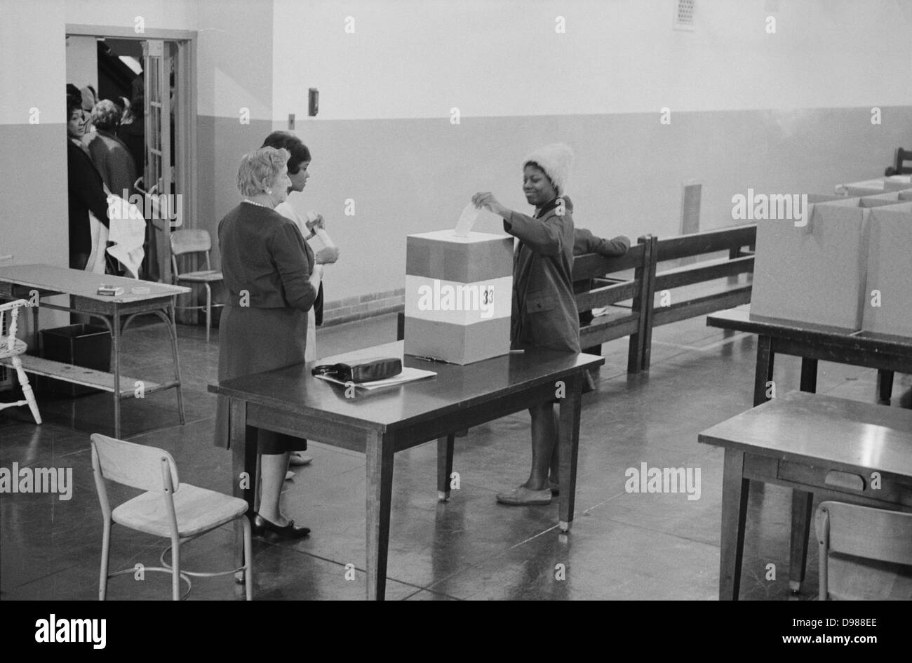 Junge afrikanische amerikanische Frau, die ihre Stimmabgabe in einer Wahlurne auf Wahllokale in der Cardoza High School Building, Washington. DC, 3. Mai 1964. Fotograf: Marion S Trikosko. Stockfoto