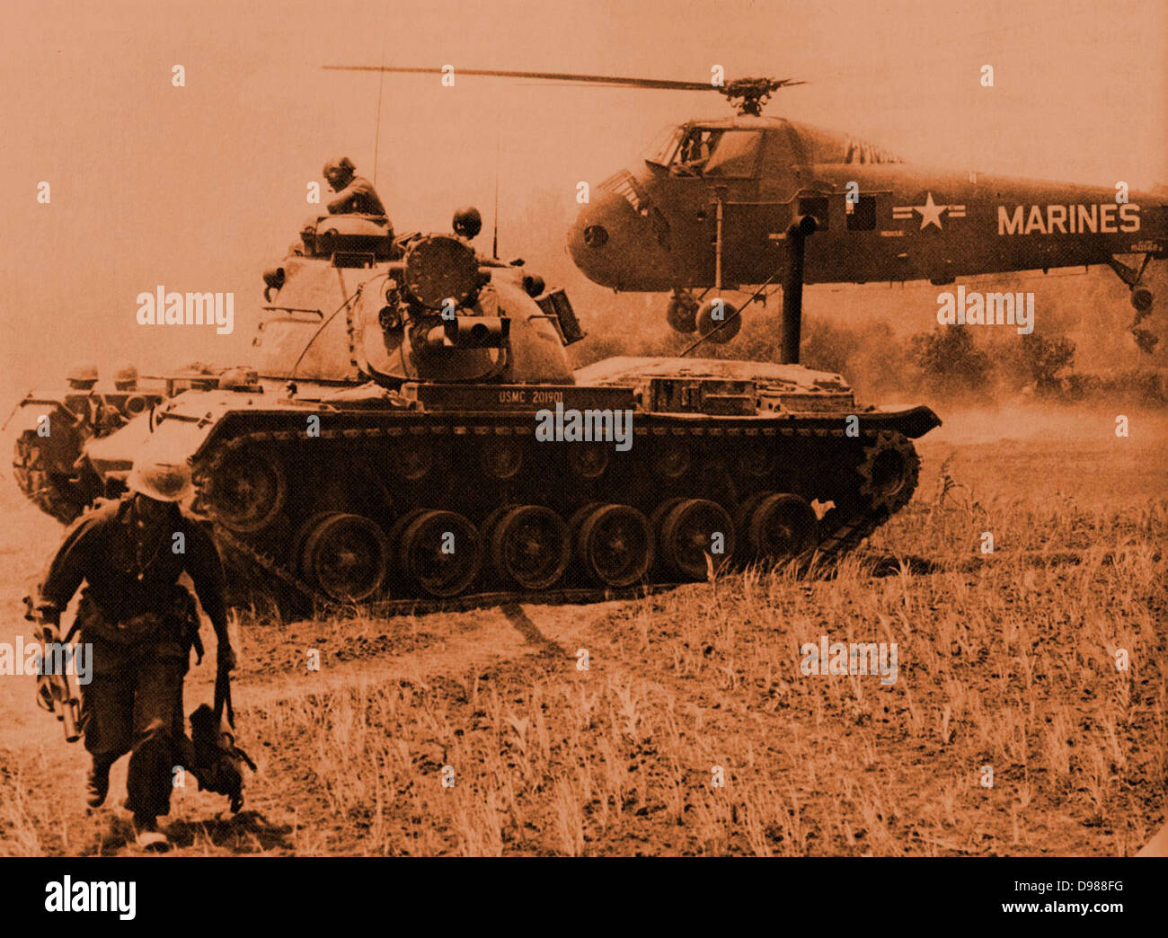 UNS MAG-16 Hubschrauber evakuiert STARLITE Opfer, während ein Marine 48 Panzer Wache steht. Die Marine auf der linken Seite führt einen M-79 Granatwerfer. Stockfoto