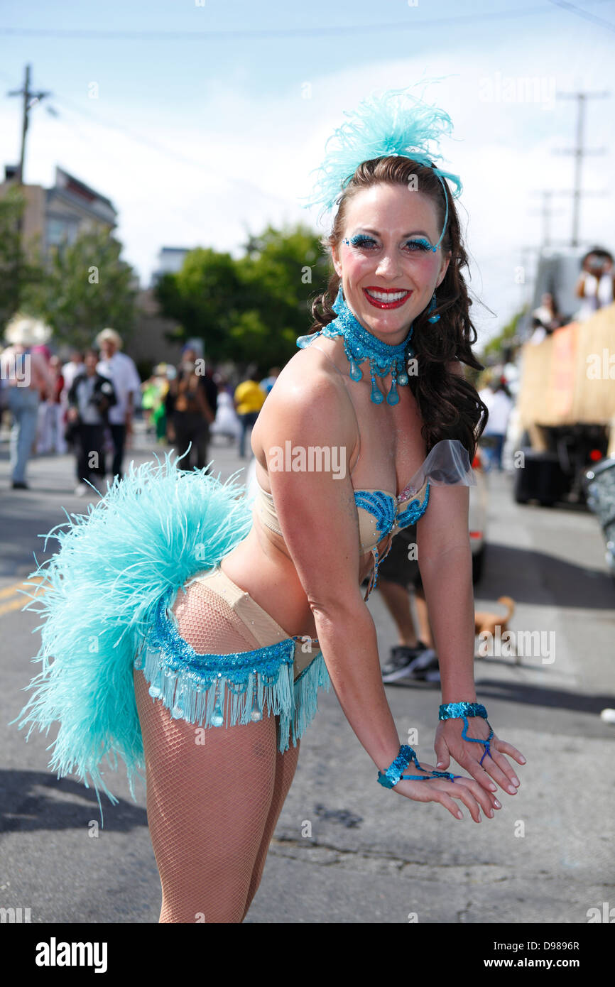 schöne Frau, die auffällig einer Pose im Karnevalstreiben im Mission District in San Francisco, Kalifornien, USA Stockfoto