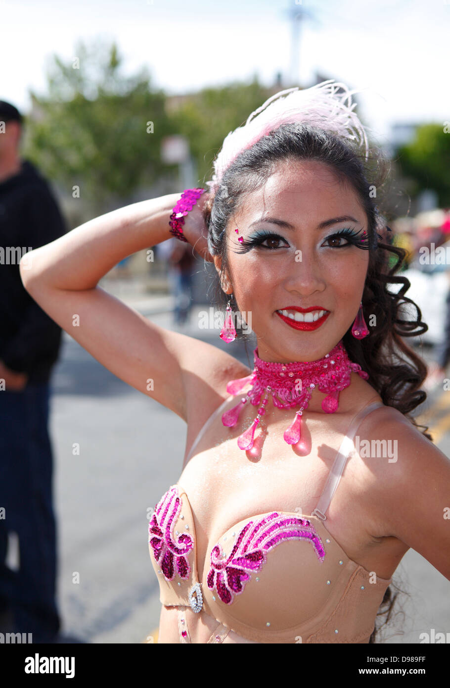 schöne Frau, die auffällig einer Pose im Karnevalstreiben im Mission District in San Francisco, Kalifornien, USA Stockfoto