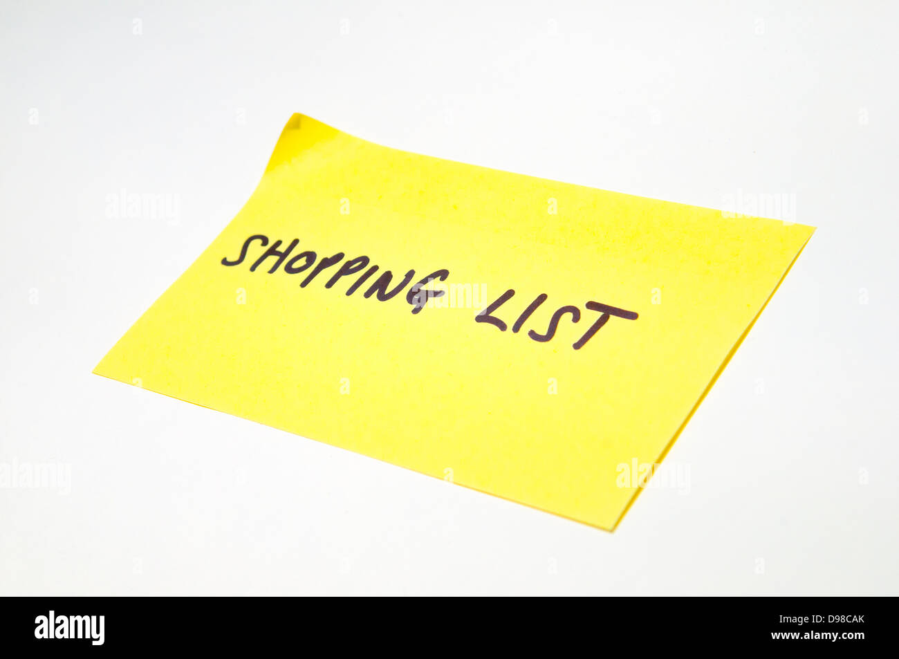 "Einkaufsliste" geschrieben auf ein gelbes post-it note Stockfoto