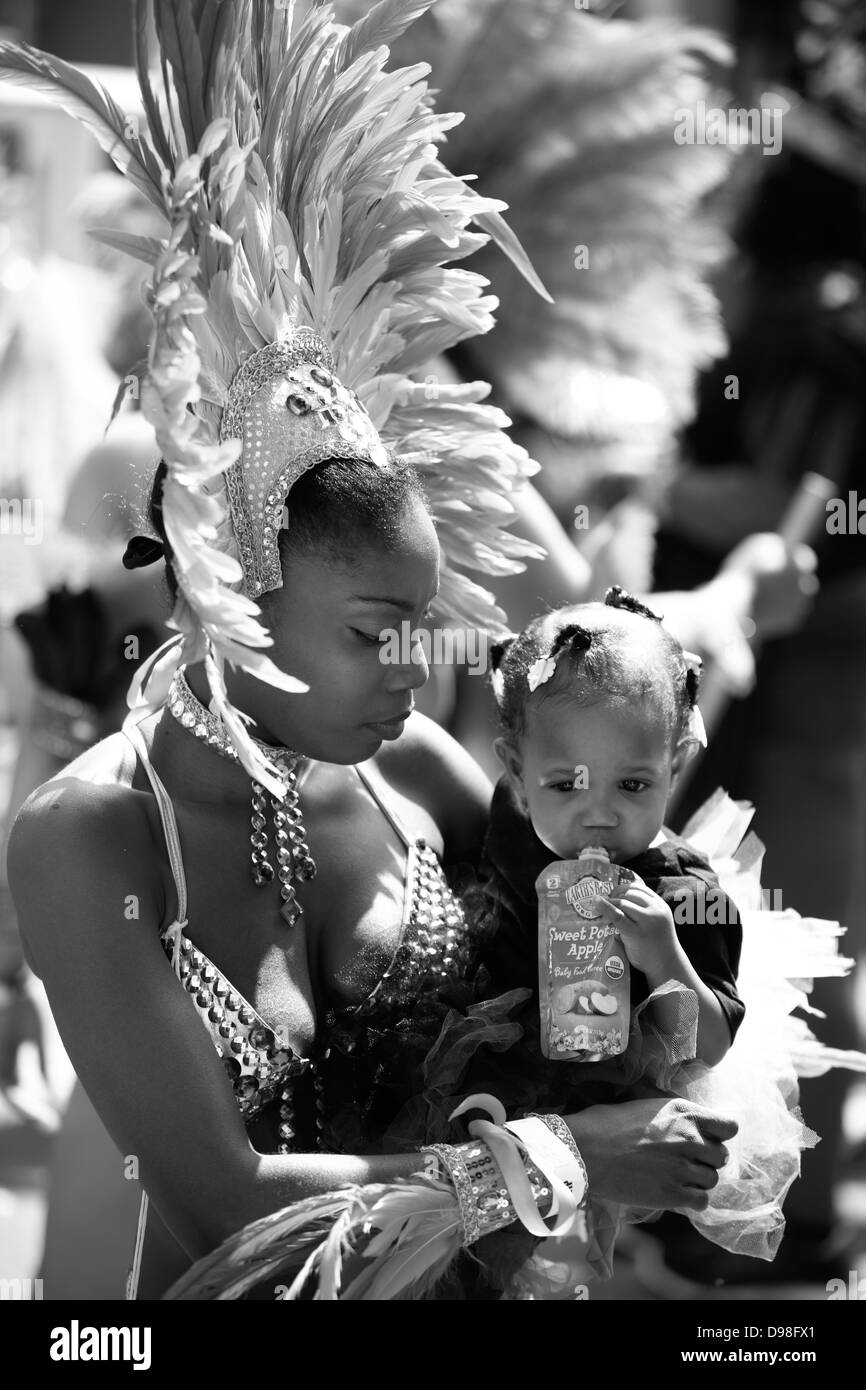Junge Mutter mit Baby im Karnevalstreiben im Mission District in San Francisco, Kalifornien, USA Stockfoto