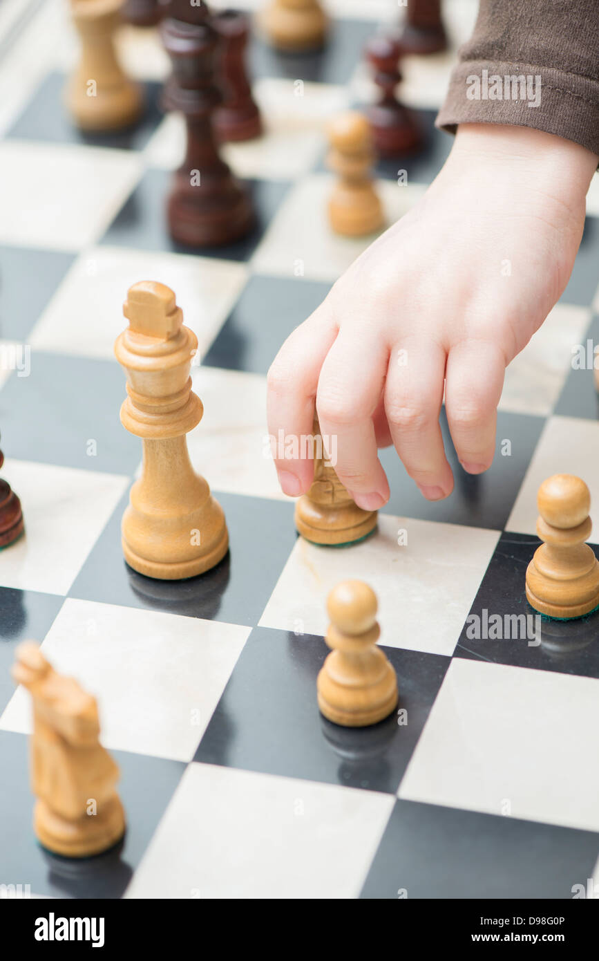 Hand des kleinen Mädchens 3-4 Jahre für Schachfigur zu erreichen Stockfoto