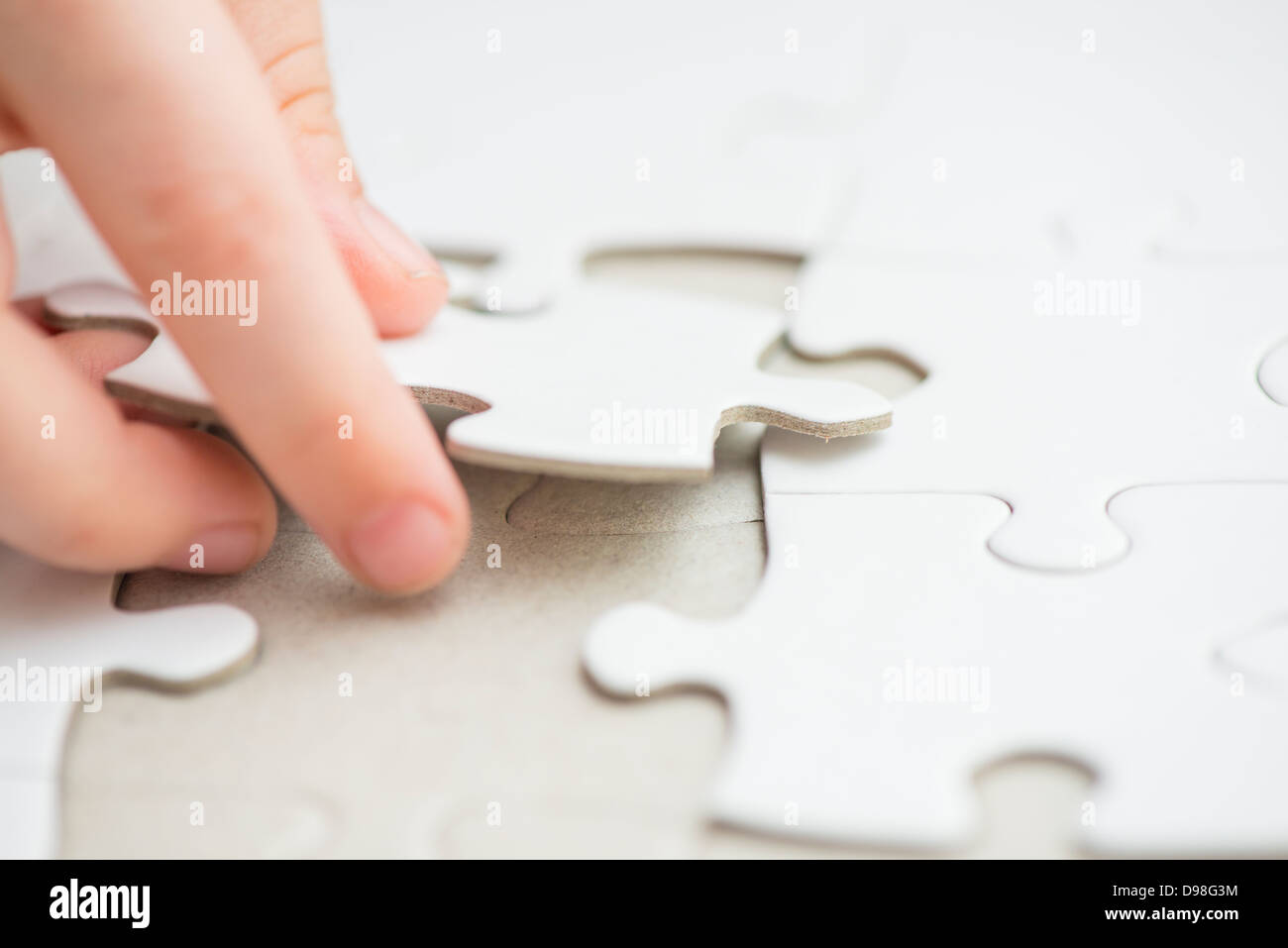 Hand von kleinen Mädchen 3-4 Jahre weiße Puzzleteil platzieren Stockfoto