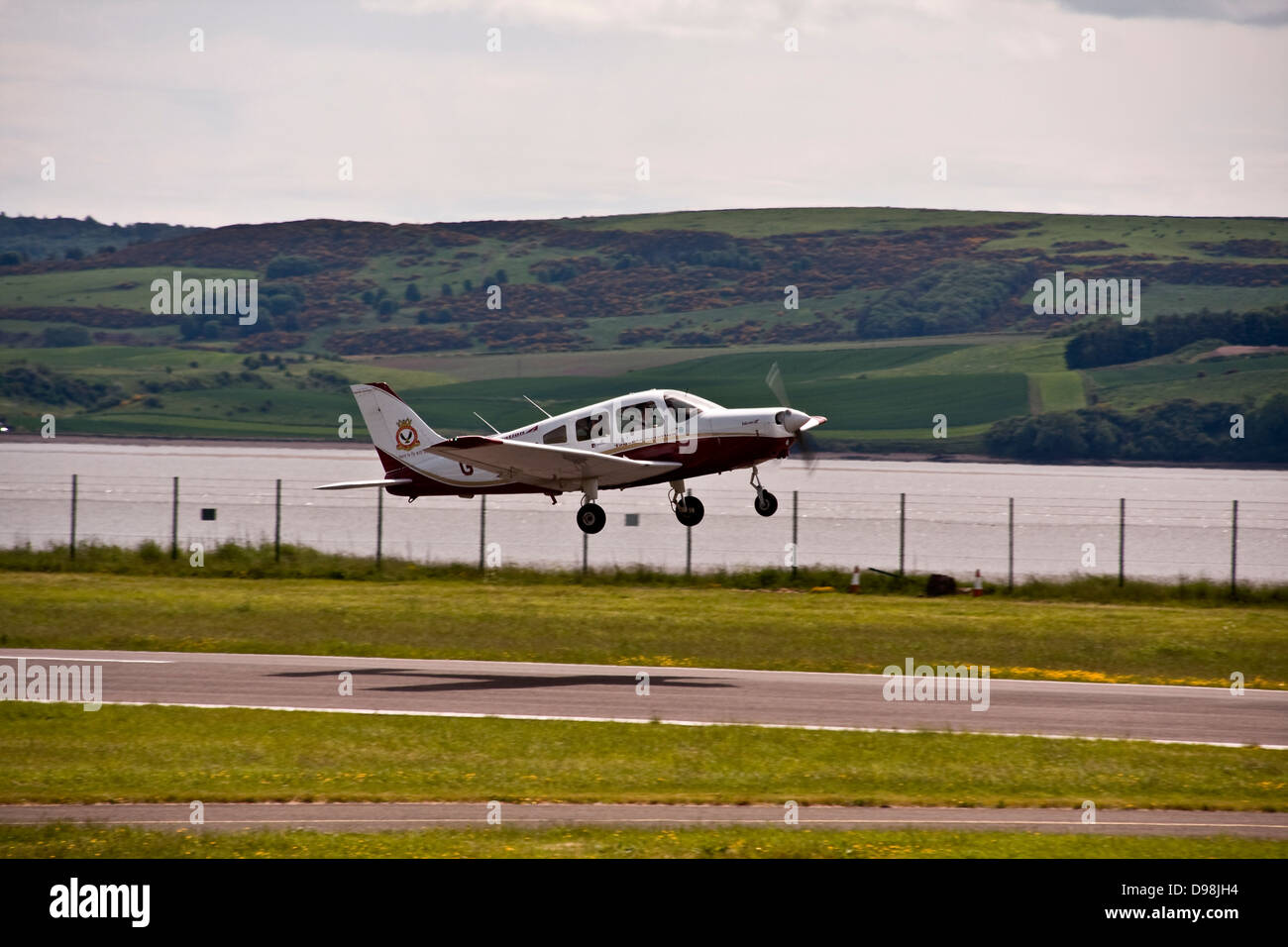 Schatten Sie auf dem Laufsteg als die Tayside Aviation G-BXOJ Training Flugzeug vom Flughafen Dundee, UK startet Stockfoto