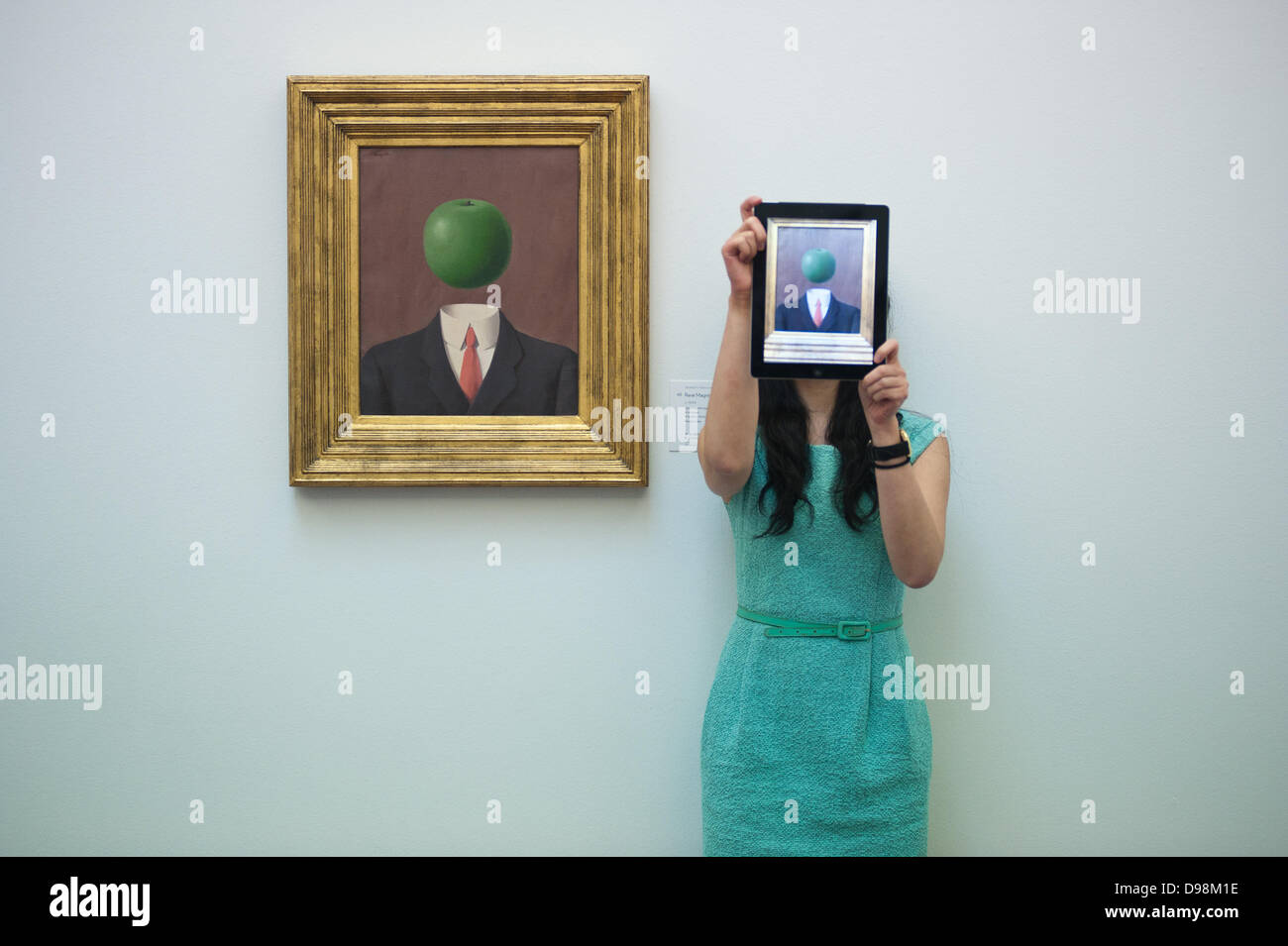 London, UK - 14. Juni 2013: eine Frau hält ihr Ipad stand neben "L'idee" von Rene Magritte (EST. 1,8-2.5million) während der Vorschau dieser Sommer-Auktion bei Sotheby's. Bildnachweis: Piero Cruciatti/Alamy Live-Nachrichten Stockfoto