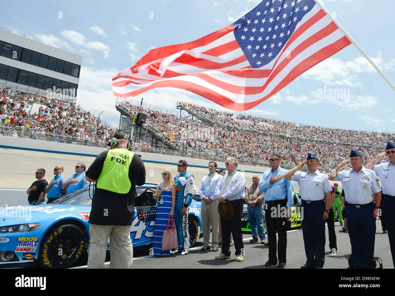 Mitglieder der 314. Recruiting Squadron Salute während die Nationalhymne während der Eröffnungsfeier der NASCAR Sprint Cup Serie FedEx 400 2. Juni 2013, auf dem Dover International Speedway. Die Flieger waren Ehrenamtliche Pit Crew-Mitglieder für den Richard-Pet Stockfoto