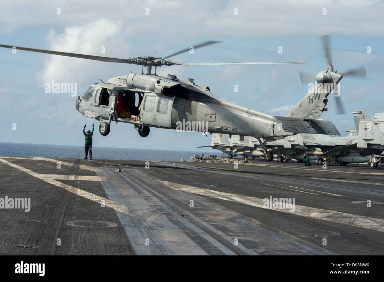 NÖRDLICHEN arabischen Meer (5. Juni 2013) A Sailor signalisiert einen MH-60 s Sea Hawk-Hubschrauber, die Ladegeräte der Hubschrauber Meer bekämpfen Squadron (HSC) 26, heben Sie das Flugdeck des Flugzeugträgers USS Dwight D. Eisenhower (CVN-69) zugewiesen. Dwight D. Eisenhower Stockfoto