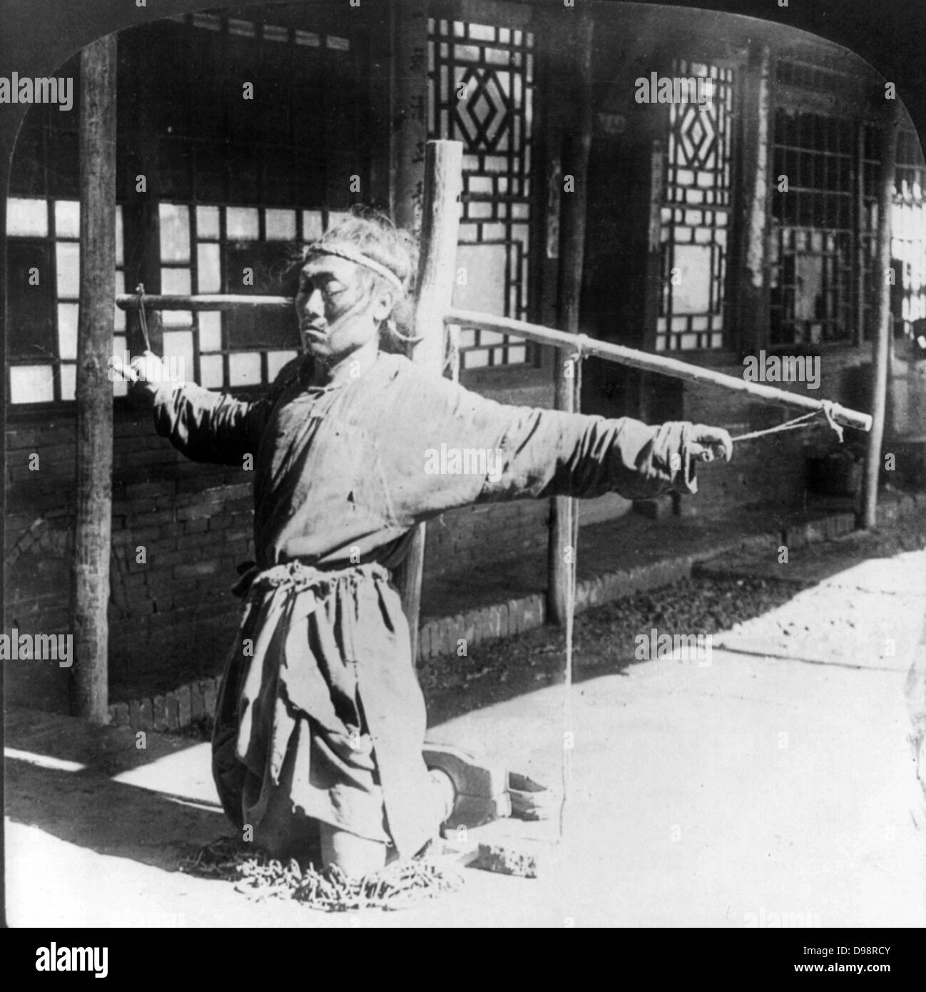 Die chinesische Justiz: Gefangene, kniend auf Ketten, Knöchel in einer Form der Aktien, oustretched Arme durch Daumen durch Kabel an einen Pfahl gebunden unterstützt. Ein paar Bilder von einer stereographische Karte c 1906. Kriminelle Stockfoto