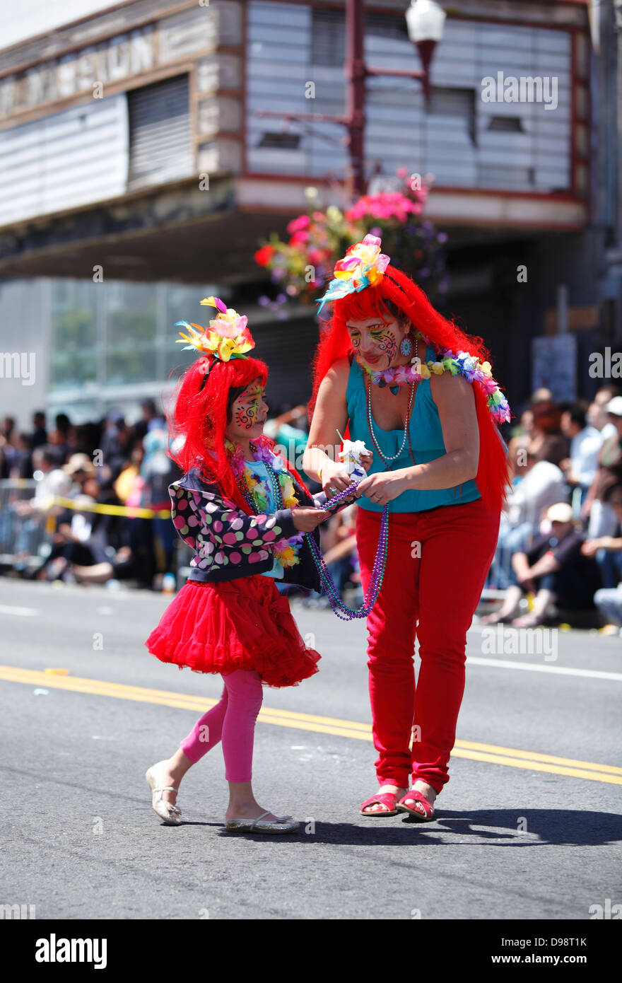 Junges Mädchen mit Mutter im Karnevalstreiben im Mission District in San Francisco, Kalifornien, USA Stockfoto