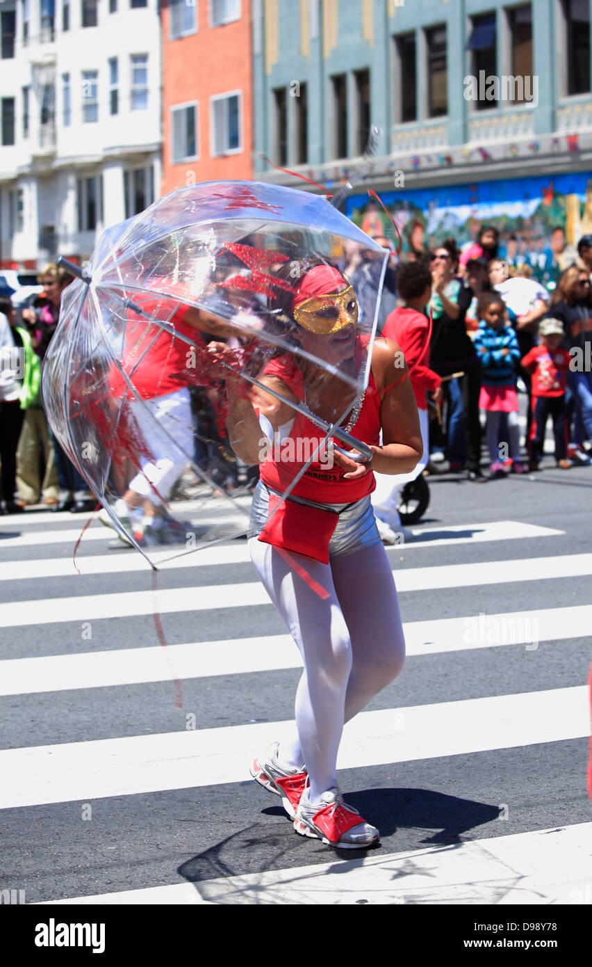 eine Tänzerin mit einem transparenten Schirm während Karnaval Parade im Mission District in San Francisco, Kalifornien, USA Stockfoto