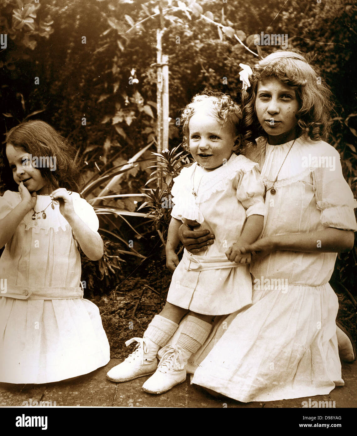 junge französische Kinder spielen im Garten. Um 1900 Stockfoto
