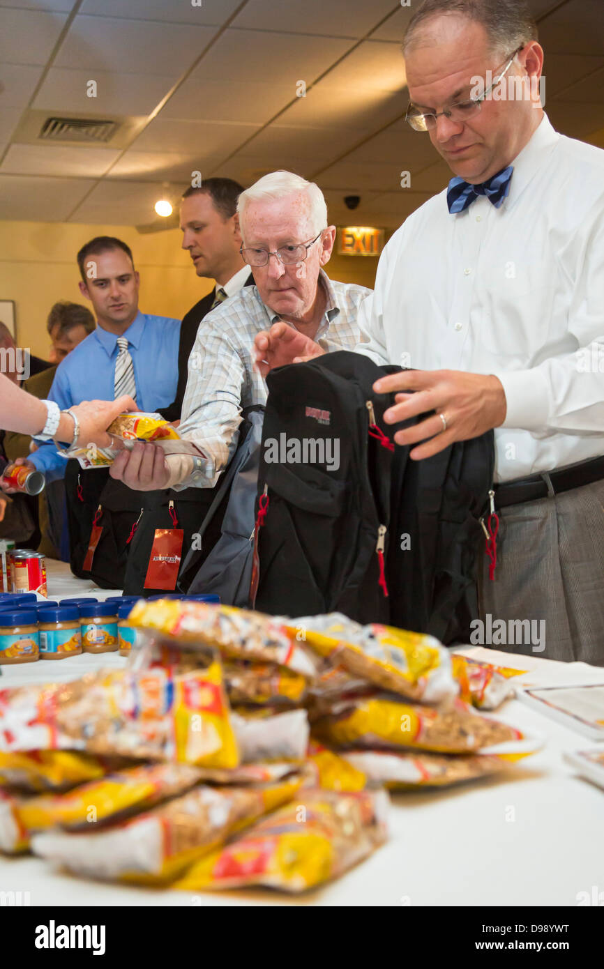 Führungskräfte in Unternehmen Sachen Rucksäcke mit Essen für hungrige Kinder Stockfoto