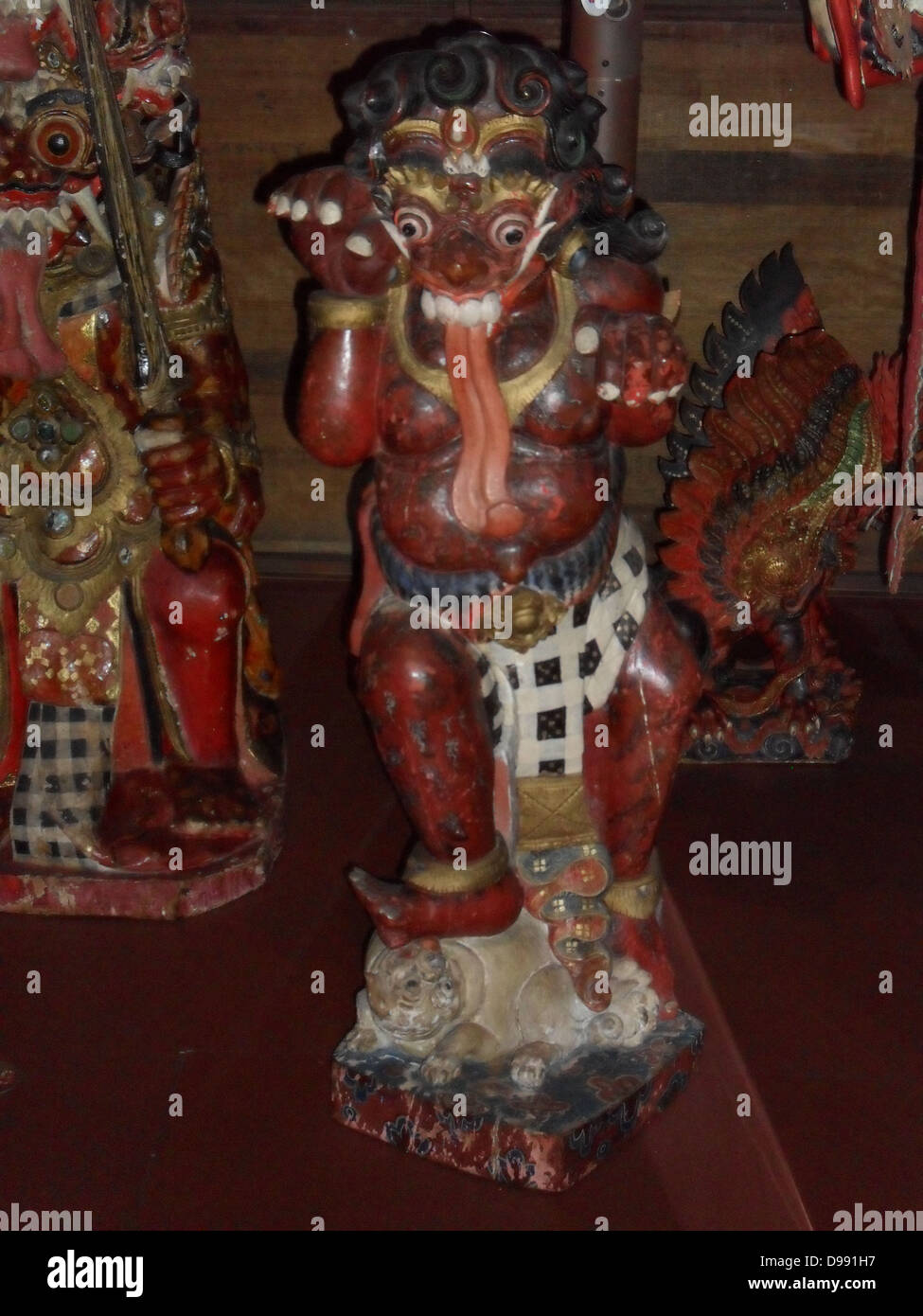 Bali (Indonesien) Hindu schnitzen in Holz. Im frühen 20. Jahrhundert. (Links). Buta, ein Dämon in der hinduistischen Mythologie. Rot symbolisiert die Wut und Lust. Stockfoto