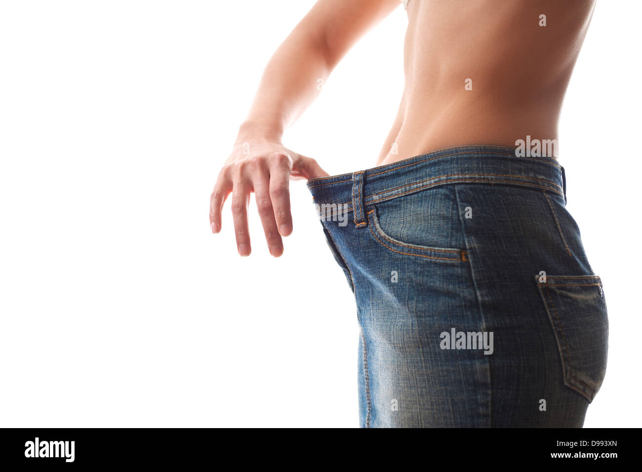 junge Frau Diäten und Gewichtsverlust trägt Jeans Kleid auf weißem Hintergrund zu betrachten Stockfoto