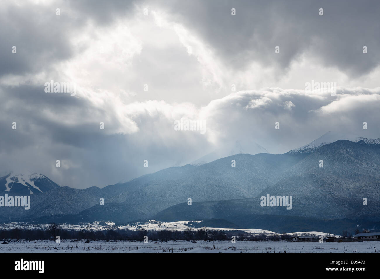 Glänzen Sie in Wolken von einem Schneesturm über Berge Stockfoto