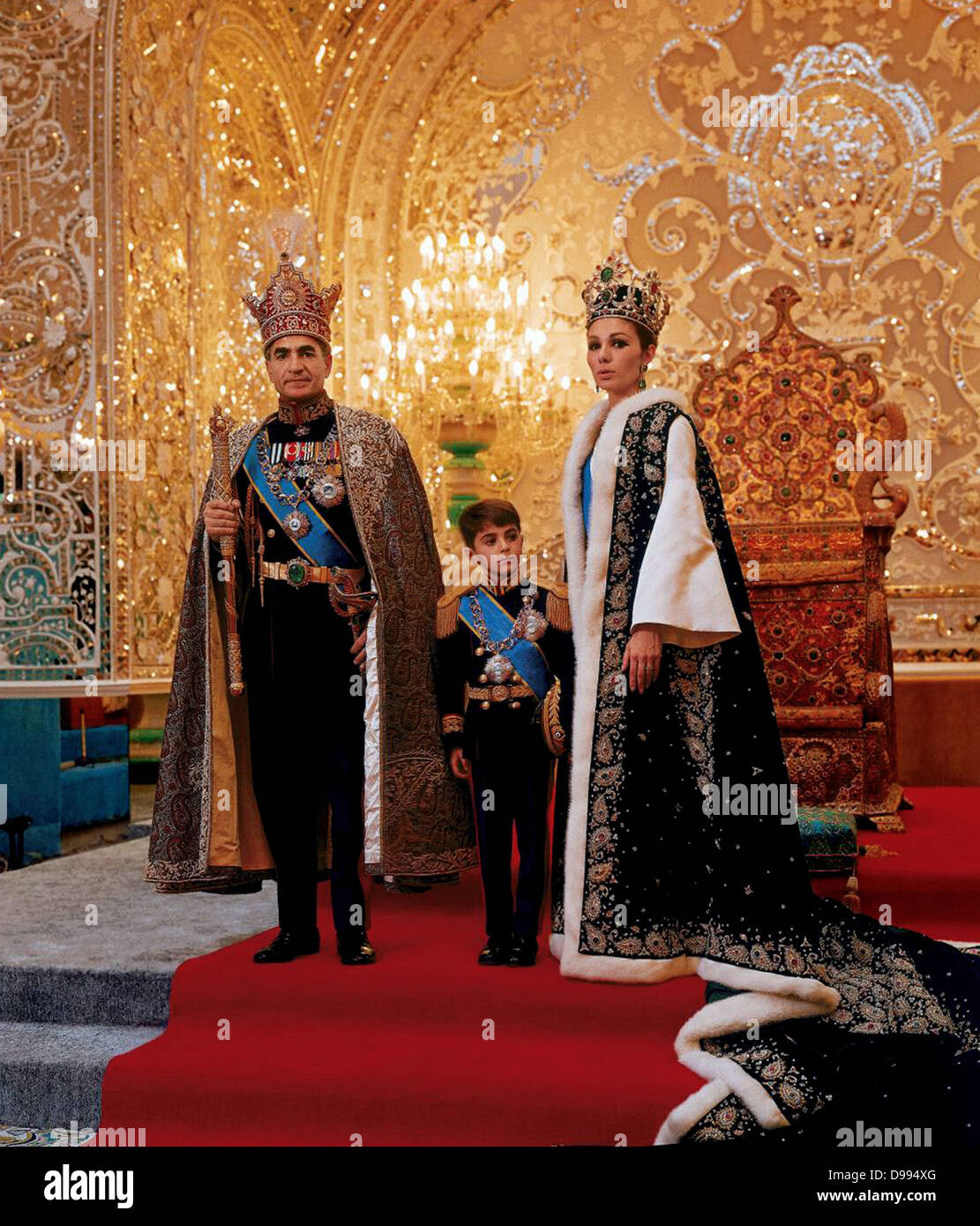 Mohammed Reza Shah Pahlavi (1919-1980) Shah von Iran 1941-1979, mit seiner dritten Frau Farah Diba und ihr Sohn Reza in den zeremoniellen Kleid vor Thron. Stockfoto