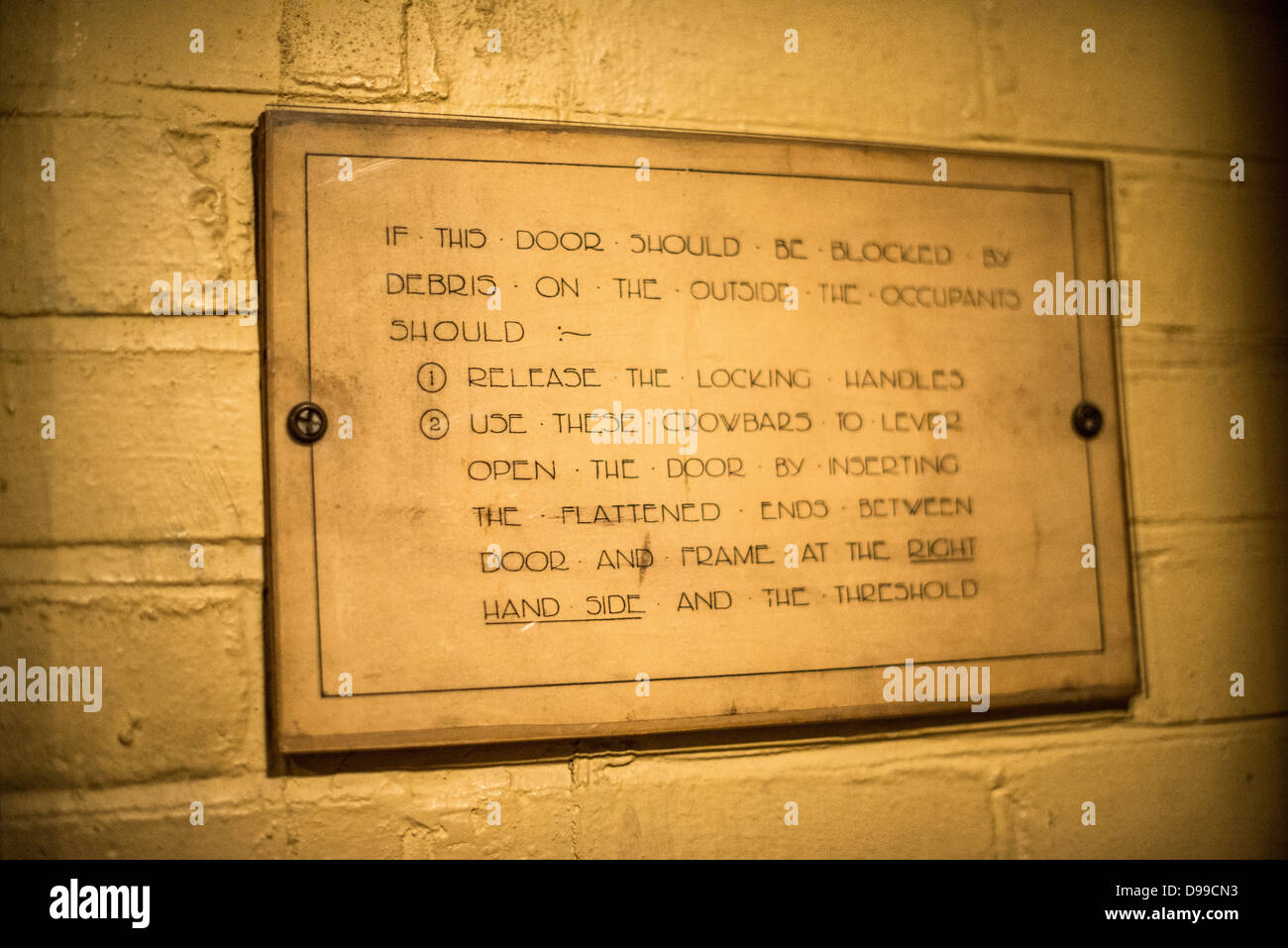LONDON, GROSSBRITANNIEN - ein Zeichen an der Wand, der detailliert beschreibt, wie sie zu entkommen, wenn Bombe Schmutz blockiert die Tür am Churchill War Rooms in London ist. Das museum, eine der fünf Zweige der Imerial Krieg Museen, bewahrt die Weltkrieg-II-U-Befehl Bunker vom britischen Premierminister Winston Churchill verwendet. Seine verkrampften Viertel wurden aus einer Umwandlung eines Untergeschosslager in der Schatzkammer Gebäude in Whitehall, London gebaut. Die U-Bahn, und unter einem ungewöhnlich stabilen Gebäude, die Cabinet War Rooms waren etwas Schutz vor den Bomben über während der Blitz fallen, gewährt wird. Stockfoto