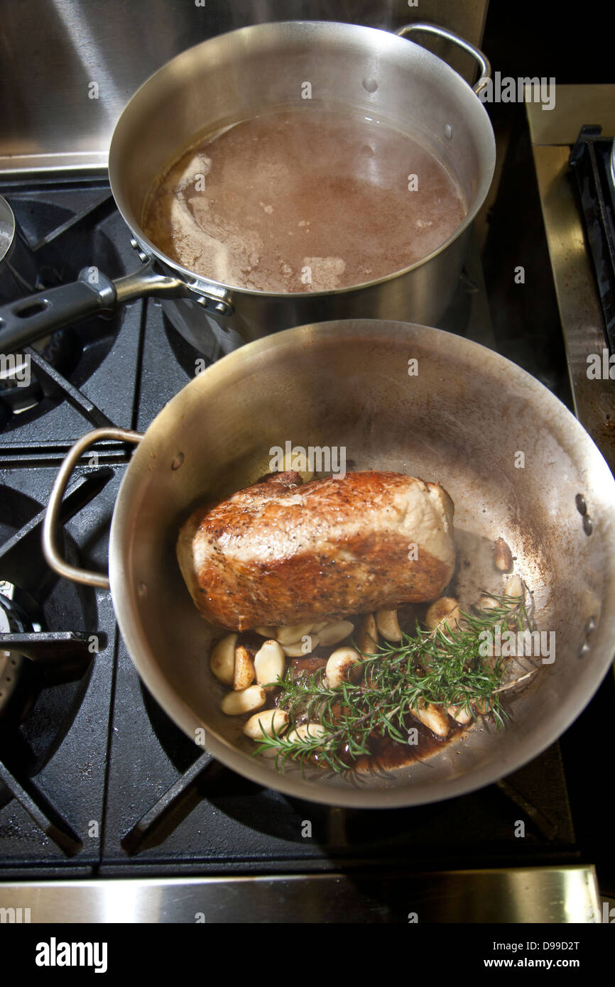 Geschmortes Fleisch in einer Pfanne mit frischen Kräutern und Rotwein Stockfoto