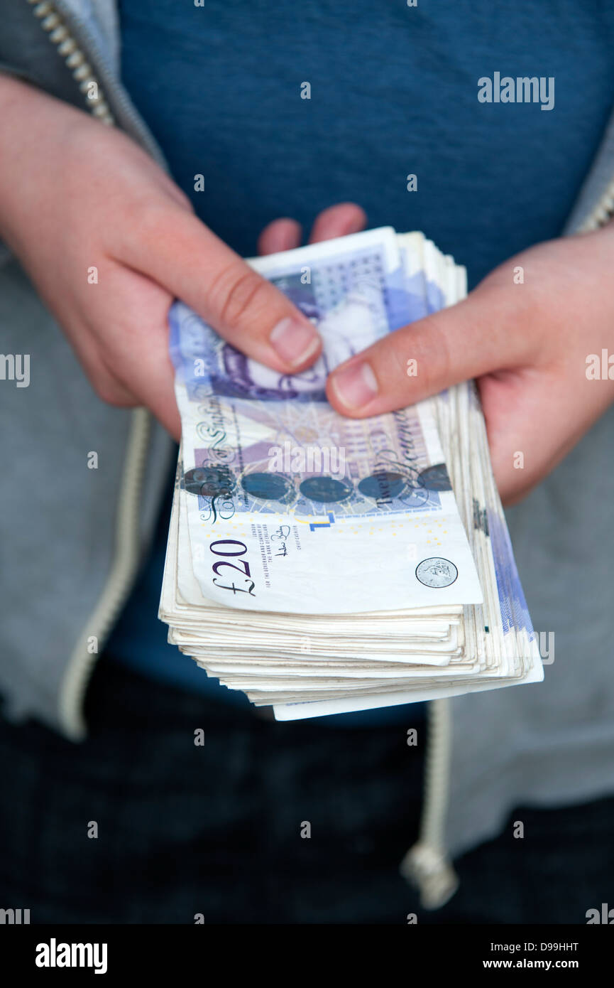 Person, die ein Bündel Geldscheine in Höhe von dreitausend Pfund Stockfoto