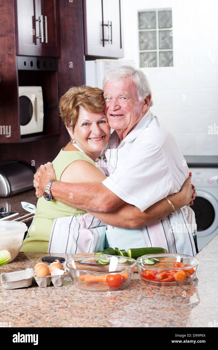 glücklich senior Liebespaar umarmt in Küche Stockfoto