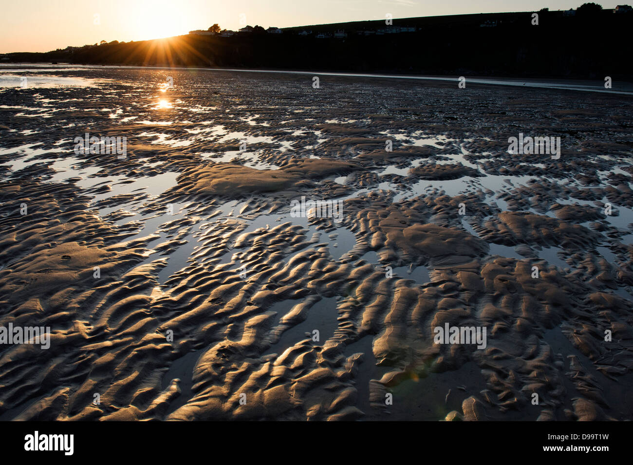 Wellige Sand und Meer Wasser auf Größe Strand bei Sonnenuntergang.  Devon, England Stockfoto