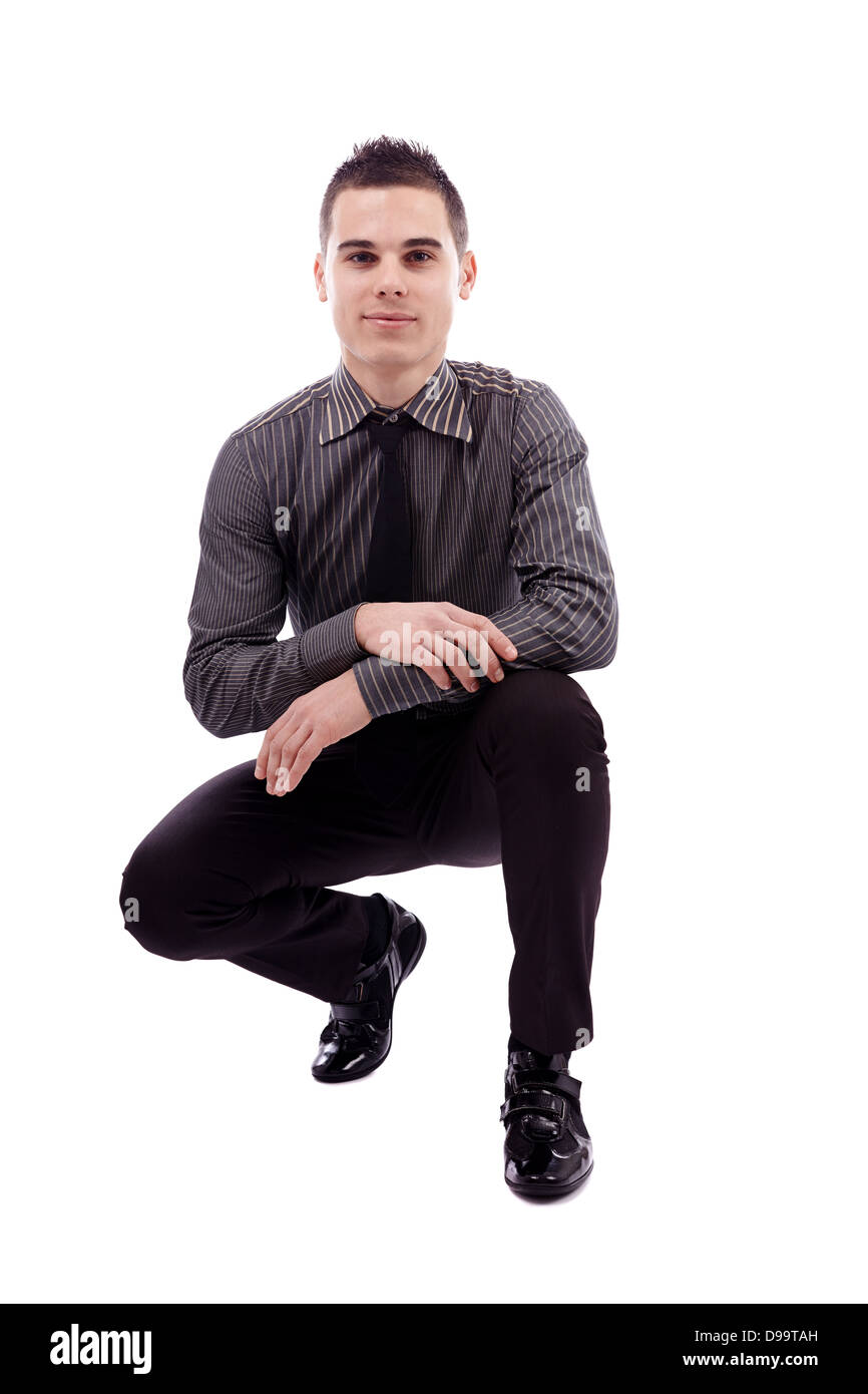 Junger Mann Crounching, in voller Länge-Pose, isoliert auf weißem Hintergrund Stockfoto