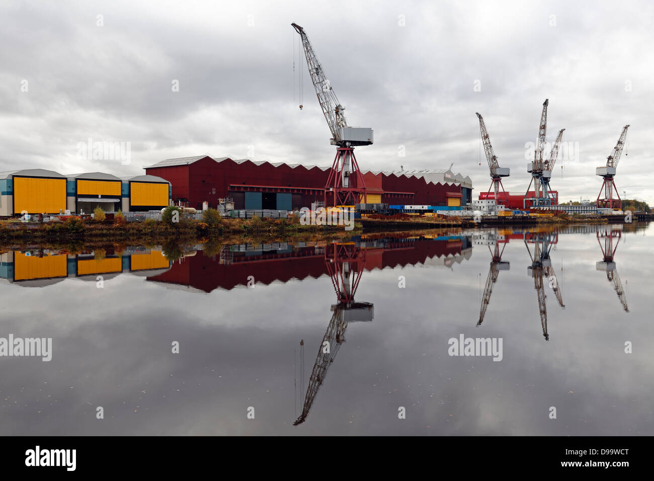 BAE Systems Shipyard Kräne und Schuppen in Govan spiegelt sich in der River Clyde in Glasgow, Schottland, Großbritannien Stockfoto