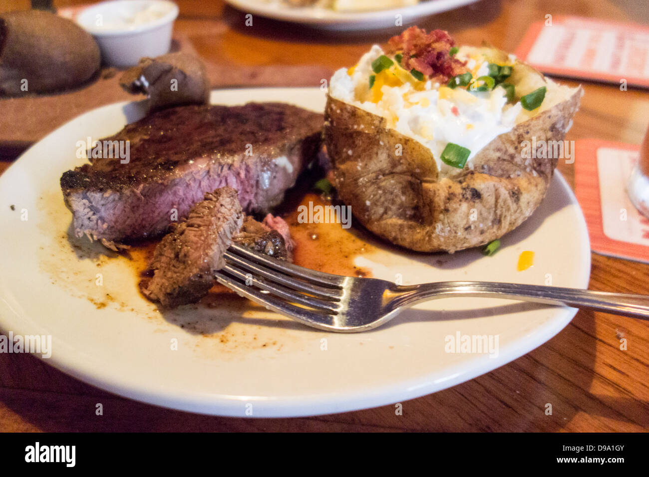 Ein Steak zum Abendessen in einem Restaurant, mit gebackenen Kartoffel. USA Stockfoto