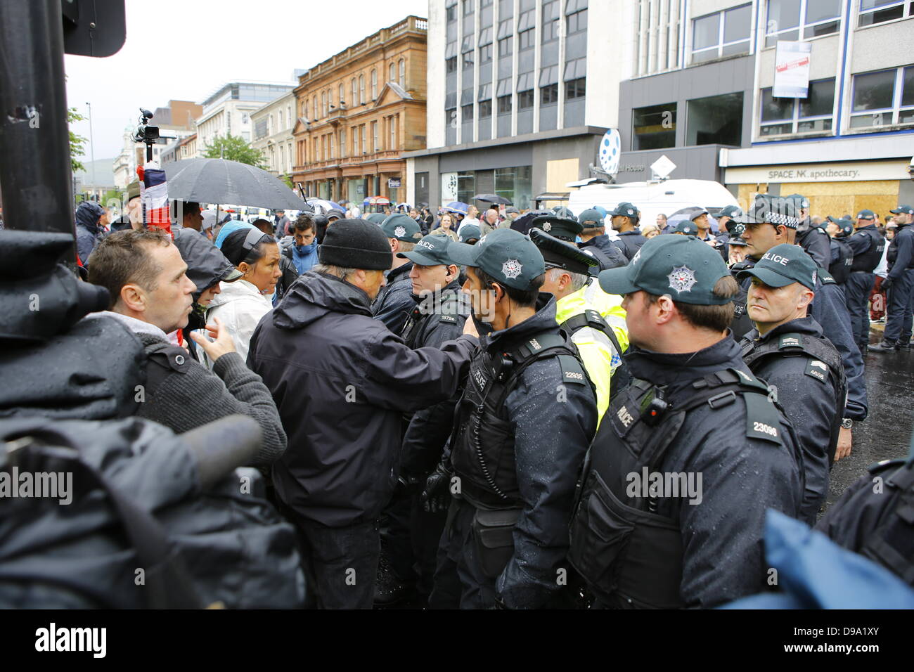 Belfast, Vereinigtes Königreich. 15. Juni 2013. Ein Unionist Demonstrant argumentiert mit einem Offizier der Polizei (Police Service of Northern-Ireland). Einige Demonstranten Loyalist, viele von ihnen gekleidet mit Union Jacks, ICTU Anti-G8-Protest außerhalb der Belfast City Hall konfrontiert und versucht, es mit Geschrei zu stören. Dank einer starken Polizeipräsenz blieb beiden Protest friedlich. Bildnachweis: Michael Debets/Alamy Live-Nachrichten Stockfoto