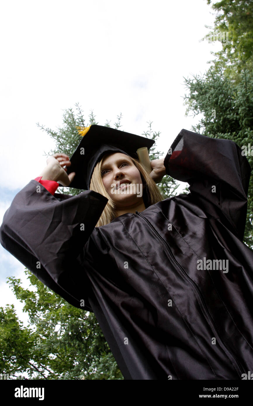 Eine junge Frau, schloss das Studium mit einem Diplom Zertifikat Nutzers ihre Mütze Stockfoto
