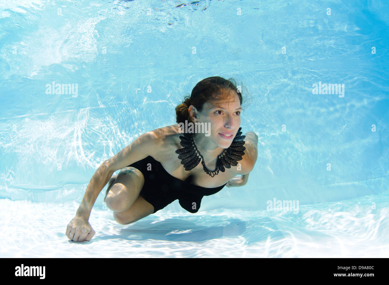 Eine junge Frau im Abendkleid schwimmt Unterwasser Model-Release verfügbar Stockfoto