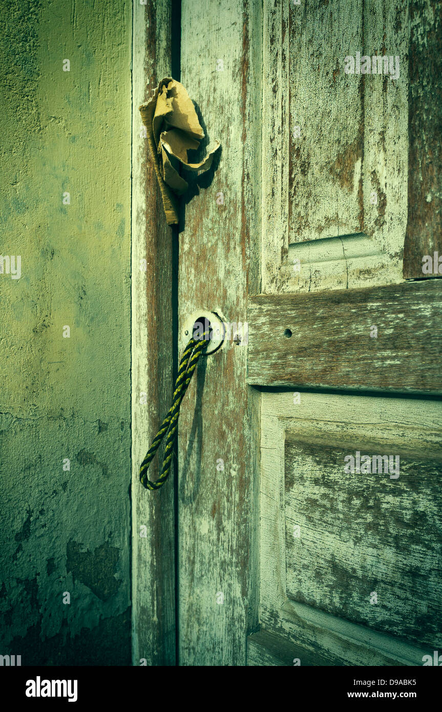 Alte Tür vernachlässigt, verblasst die Farbe mit String Ziehgriff Stockfoto