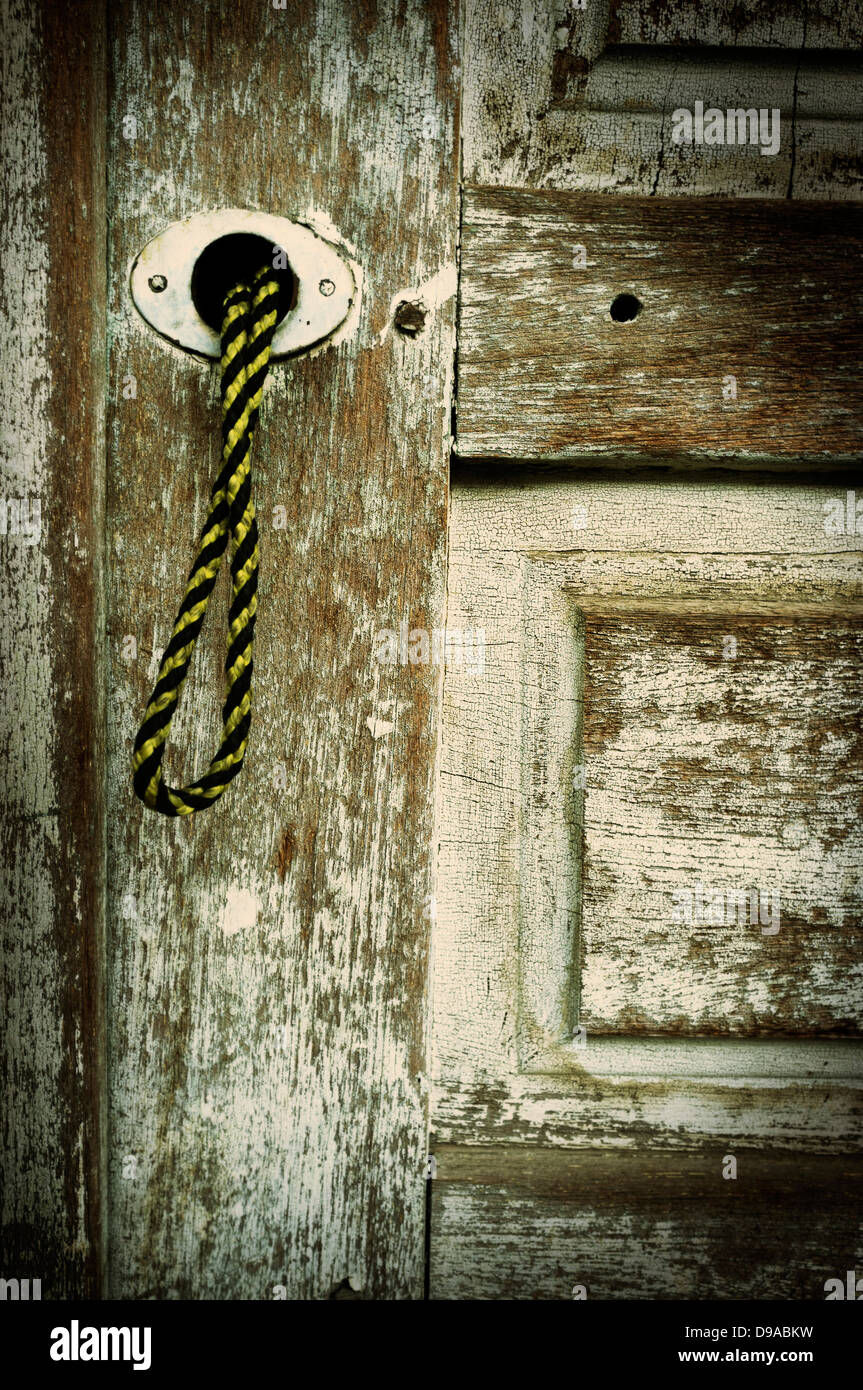 Alte Tür vernachlässigt, verblasst die Farbe mit String Ziehgriff Stockfoto