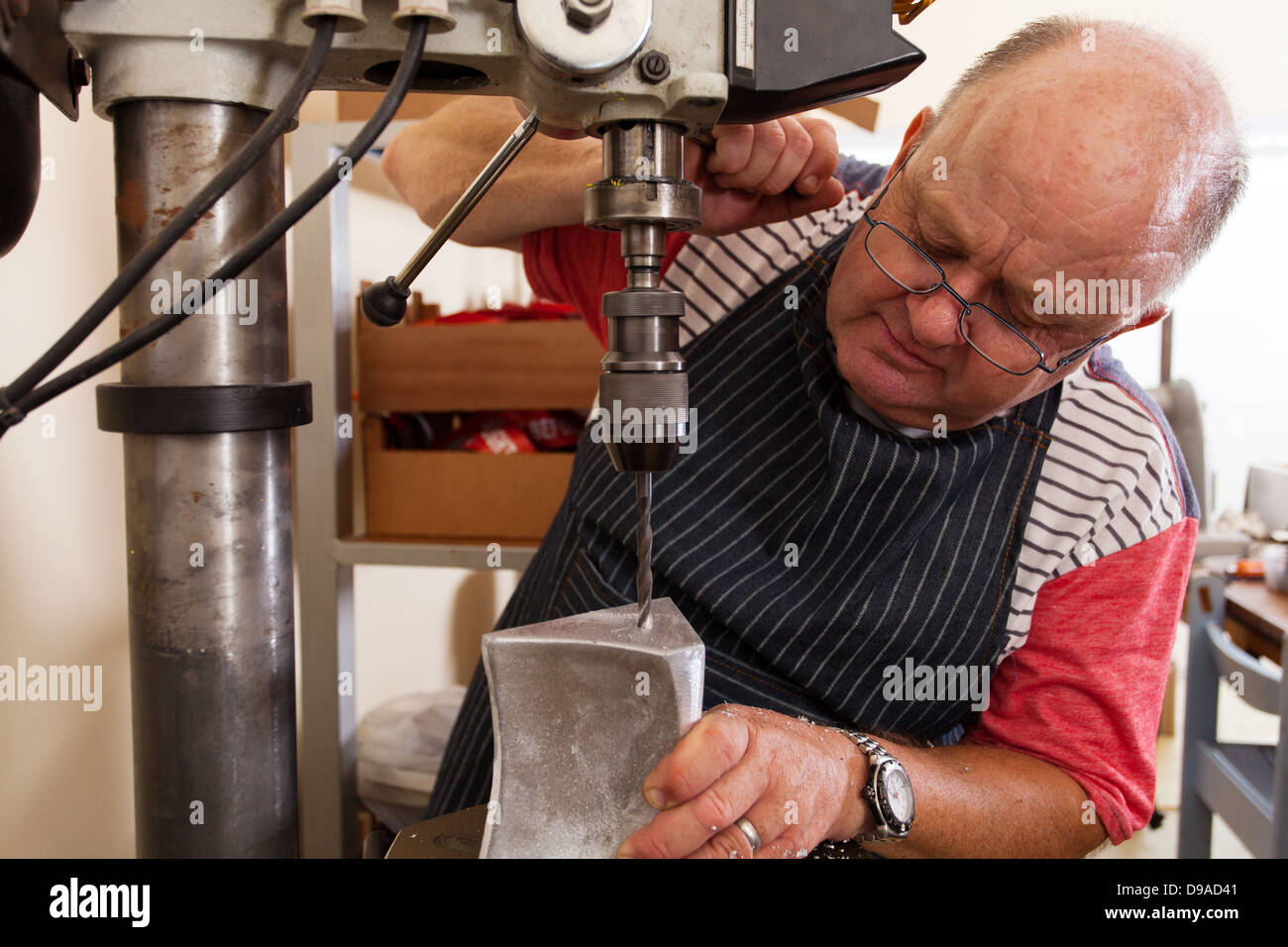 Senior Metallarbeiter mit industriellen Bohrmaschine in Werkstatt Stockfoto