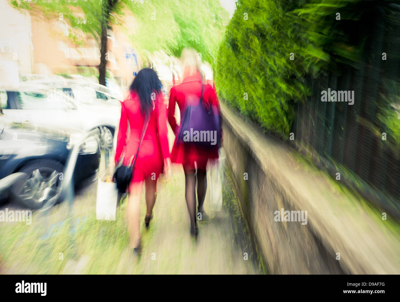 Zwei unkenntlich Fashioable Frauen in roten gehen voran, vorsätzliche Bewegungsunschärfe Stockfoto