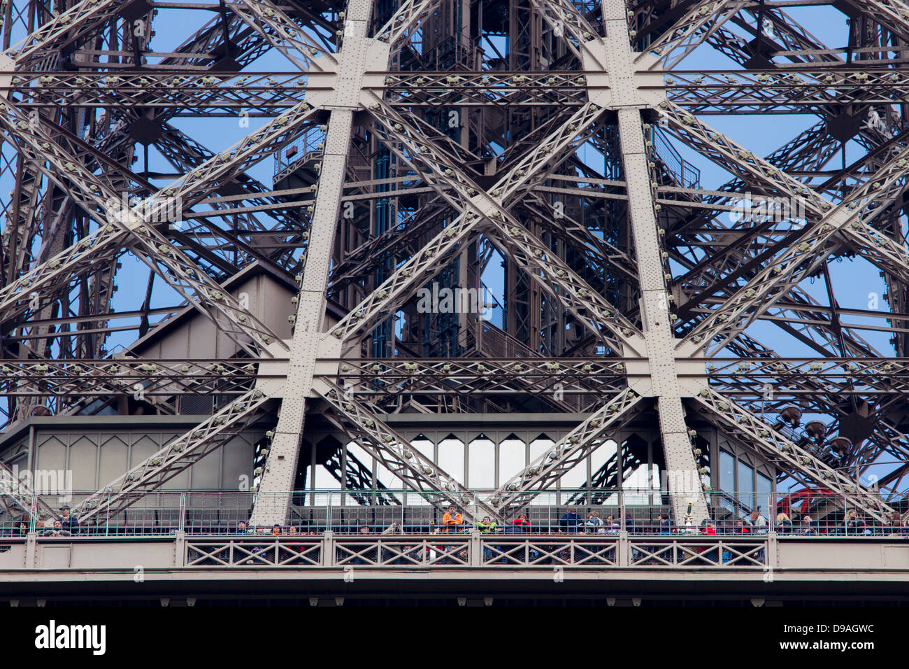 Touristen mit Blick vom ersten Plattform des Eiffelturms unter komplexen Gitter Schmiedearbeiten Stockfoto