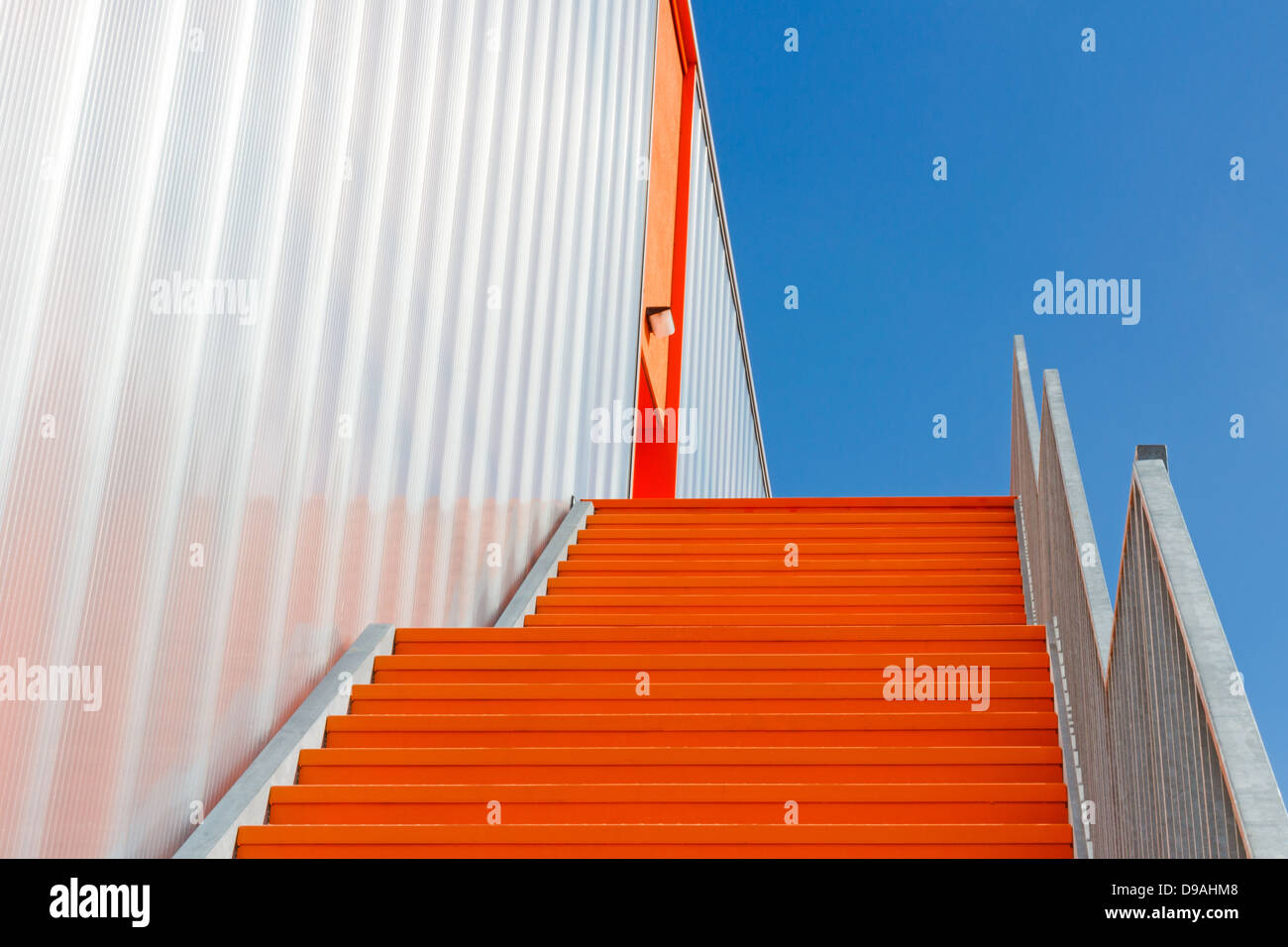 Unten die orange Nottreppe gegen den blauen Himmel Stockfoto
