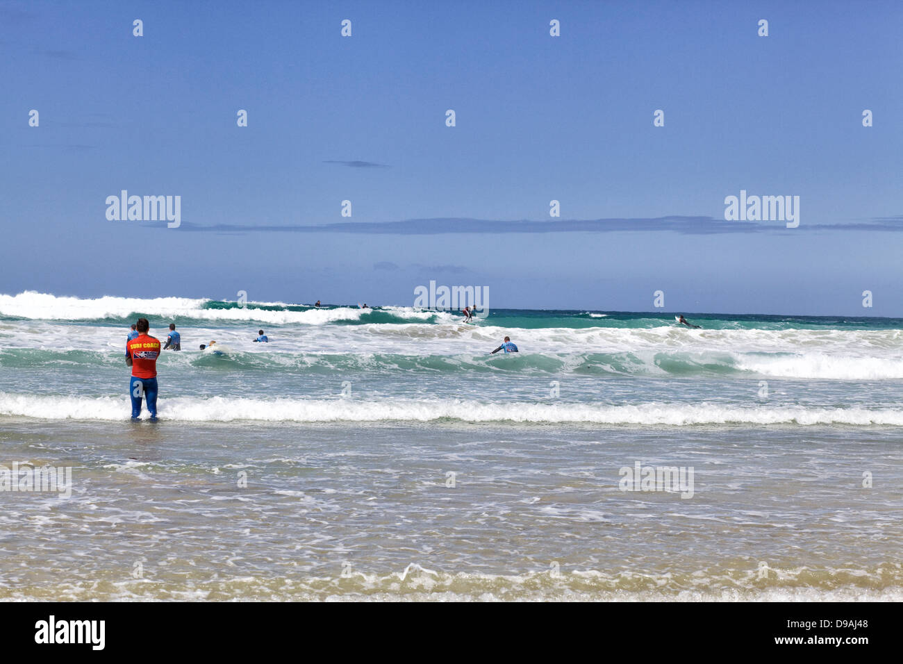 Surf School Trainer im Wasser Surfer beizubringen, Newquay Cornwall Strand surfen Stockfoto