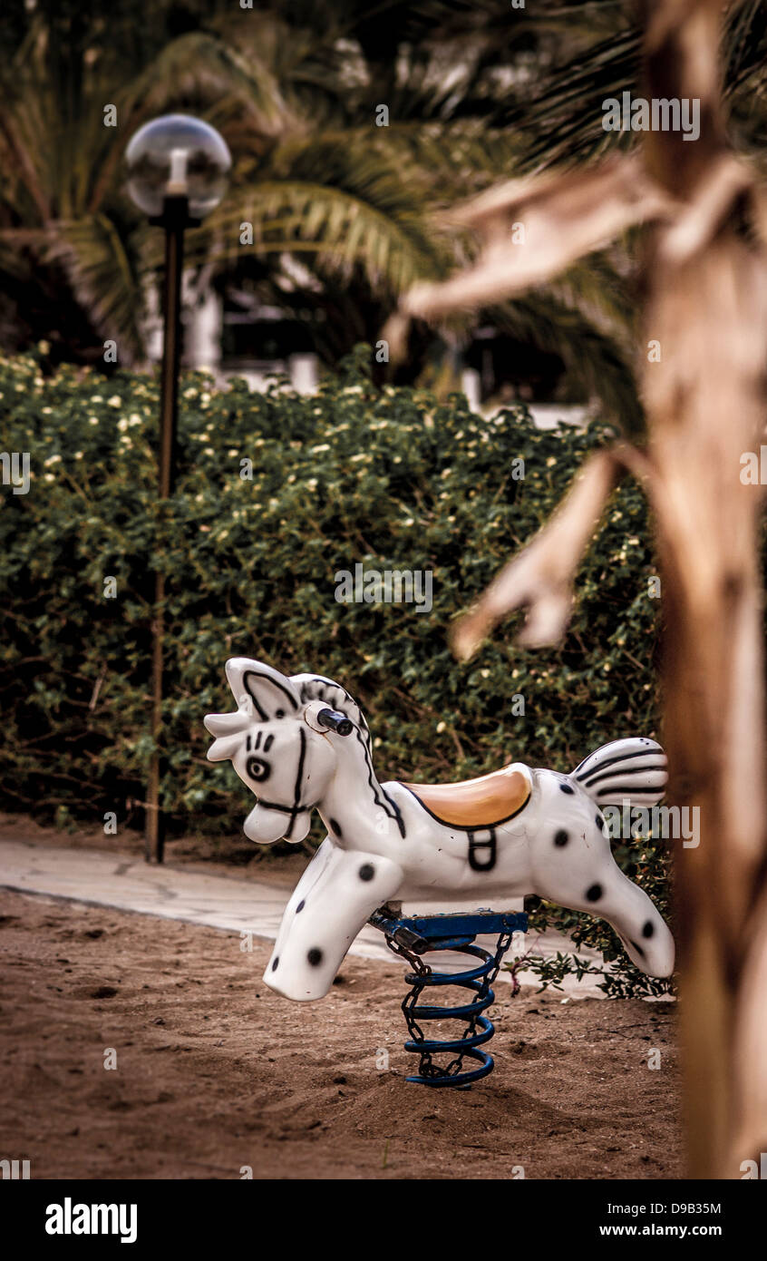 Frühlingsschaukelpferd im Spielplatz im Freien für Kinder im Ferienresort. Stockfoto