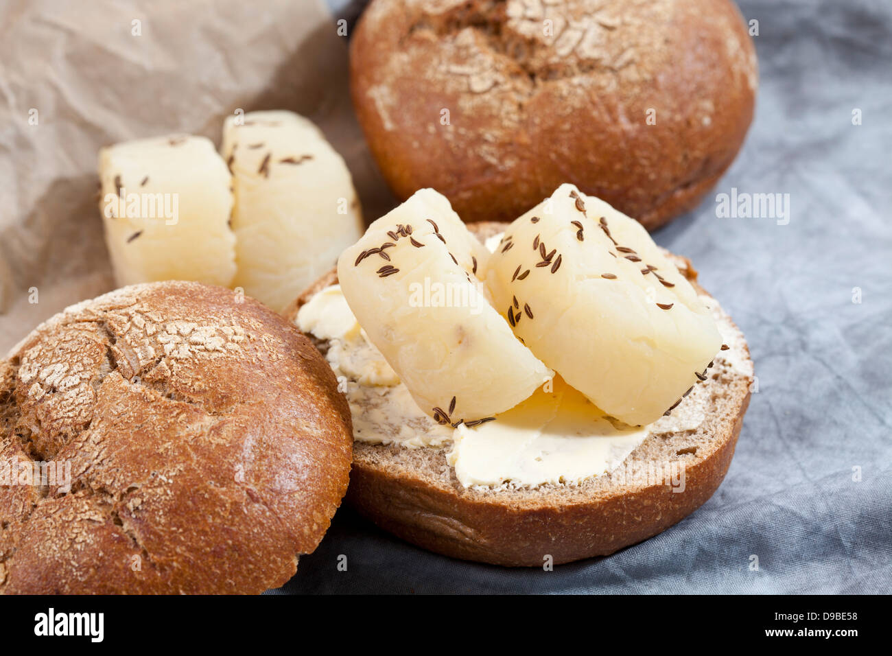 Roggenbrötchen mit Harzer Roller Käse und Kümmel auf Textil, Nahaufnahme Stockfoto