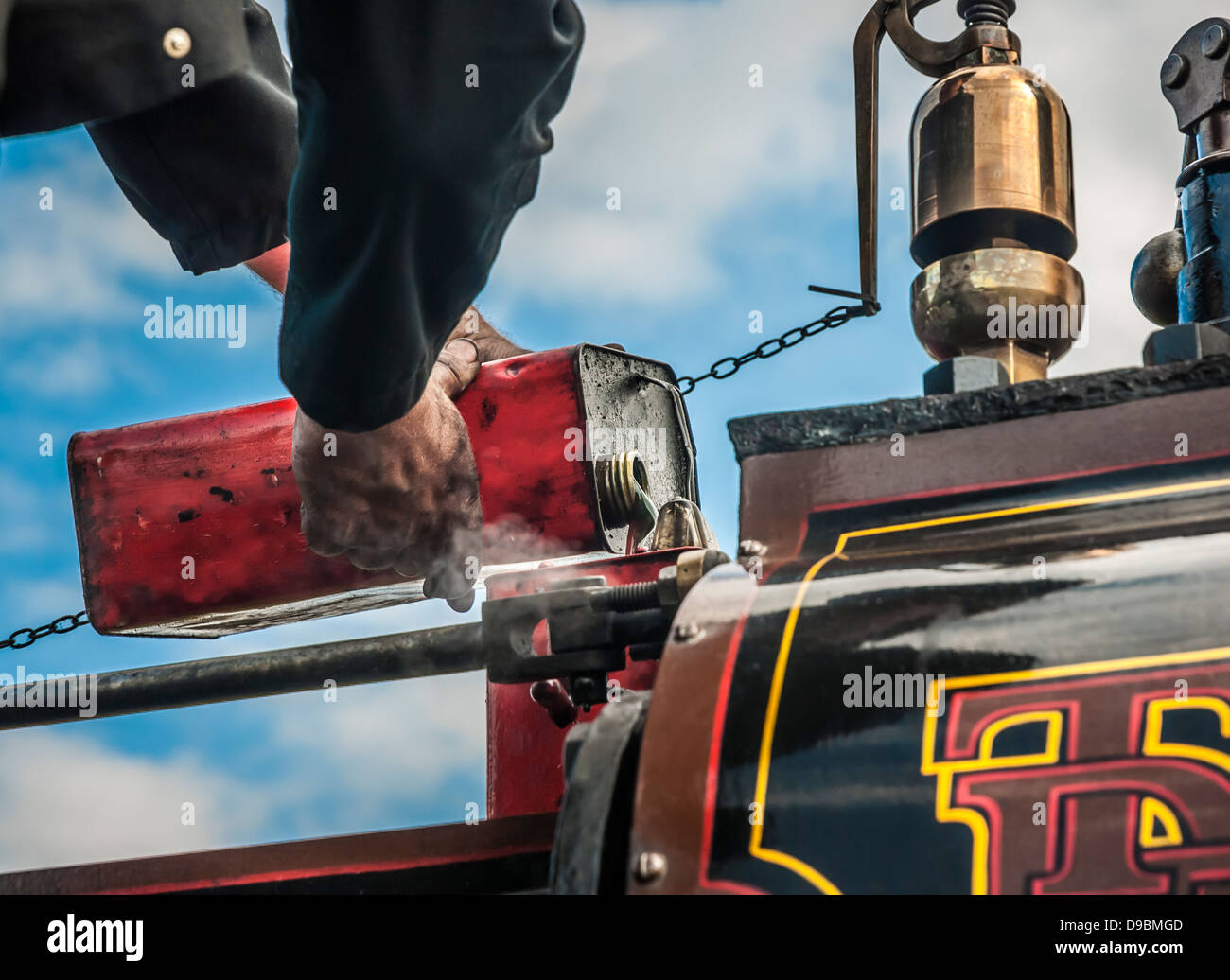 Ein Mann seine Dampftraktor mit Öl nachfüllen. Stockfoto