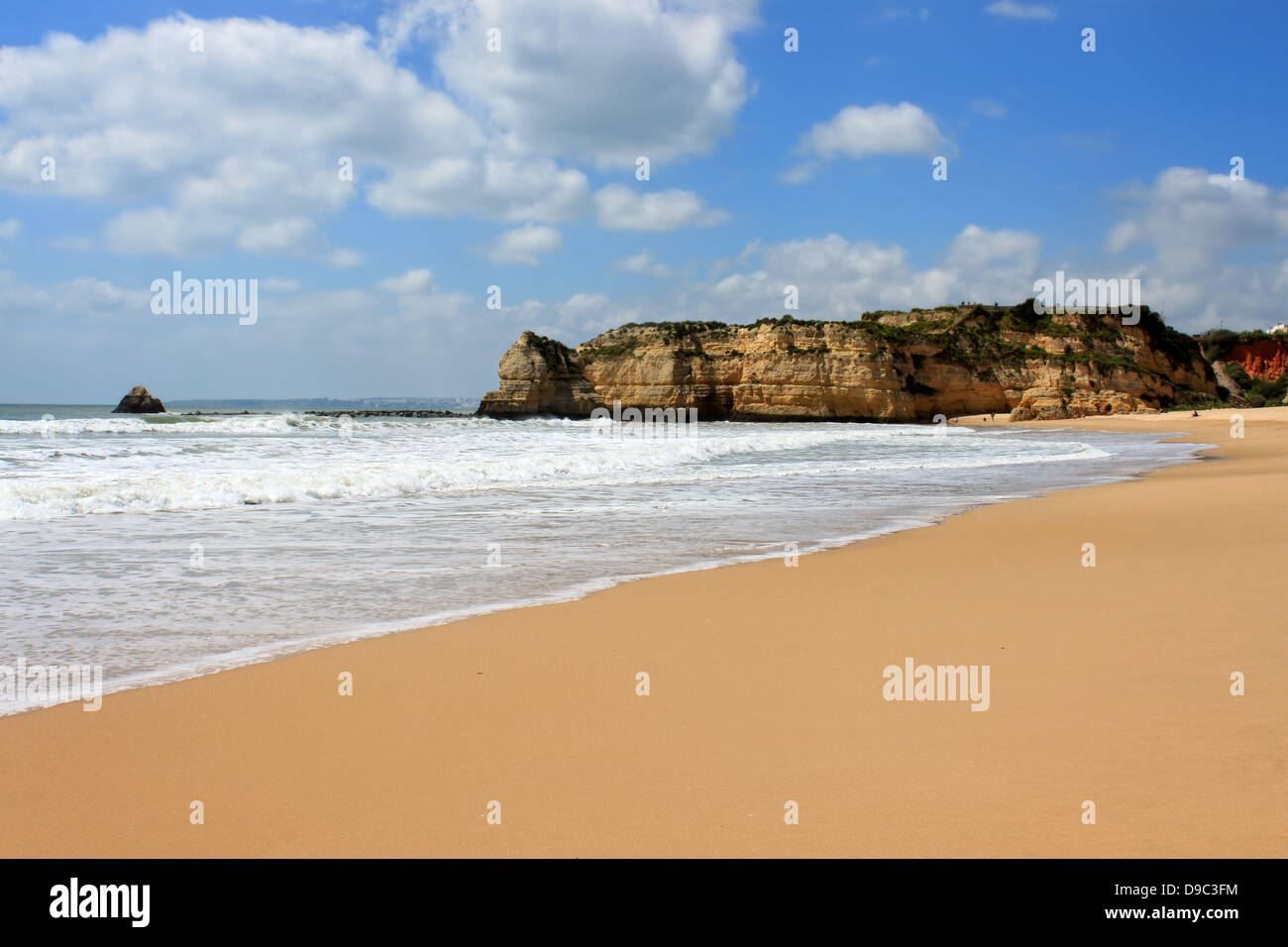 Wellen entlang der goldenen Sandstrand verbauter und ockerfarbenen Klippen von Praia da Rocha an der Algarve, Portugal Stockfoto