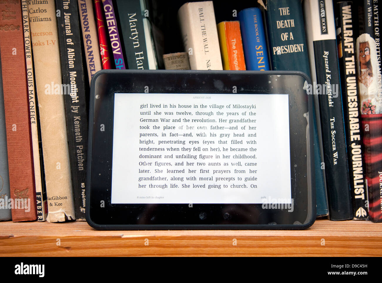 Kindle e-Book-Gerät und physische Bücher im Regal, London Stockfoto