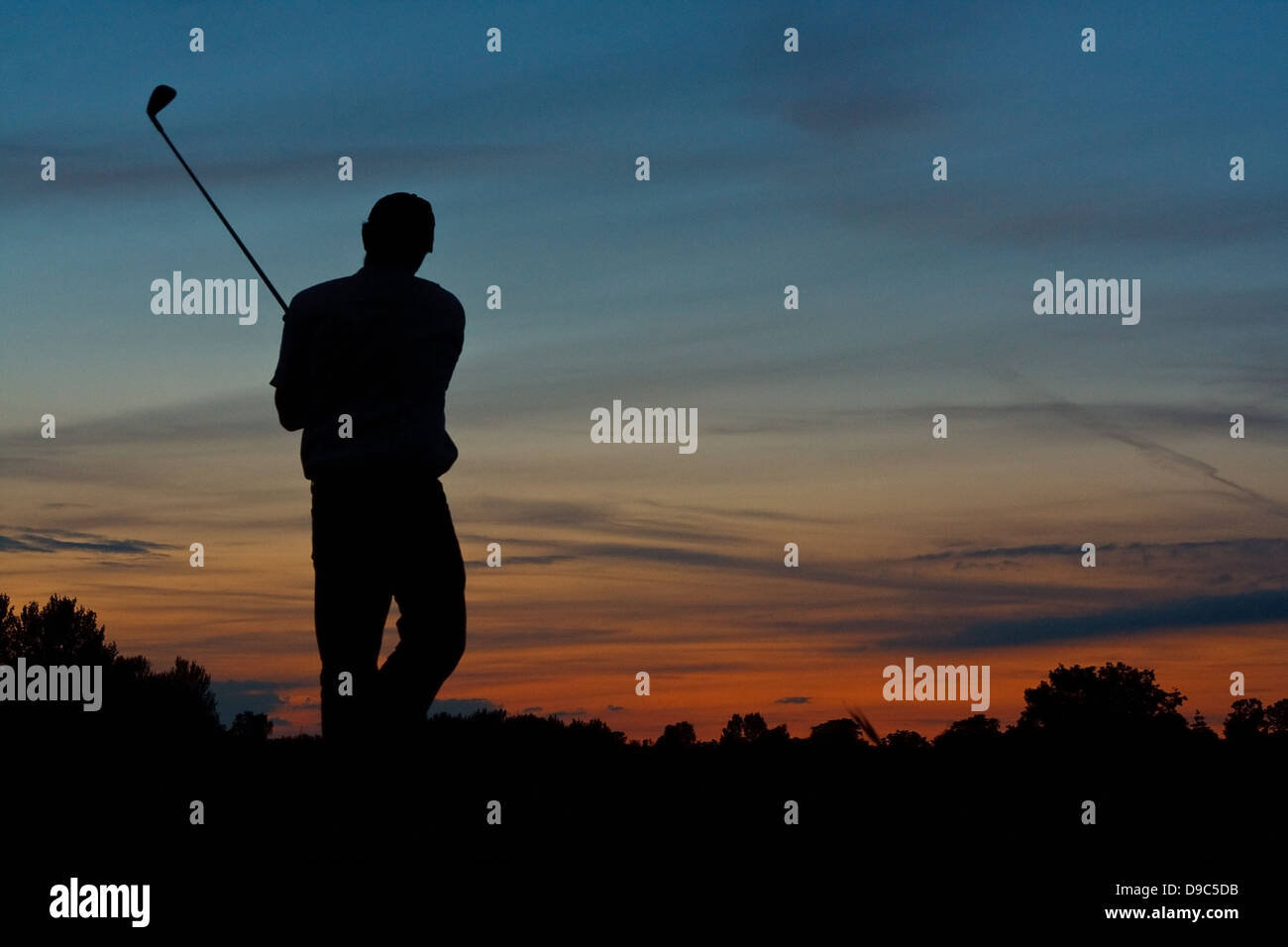 Silhouette eines einsamen Golfers Beendigung einer Partie Golf in der Abenddämmerung Stockfoto