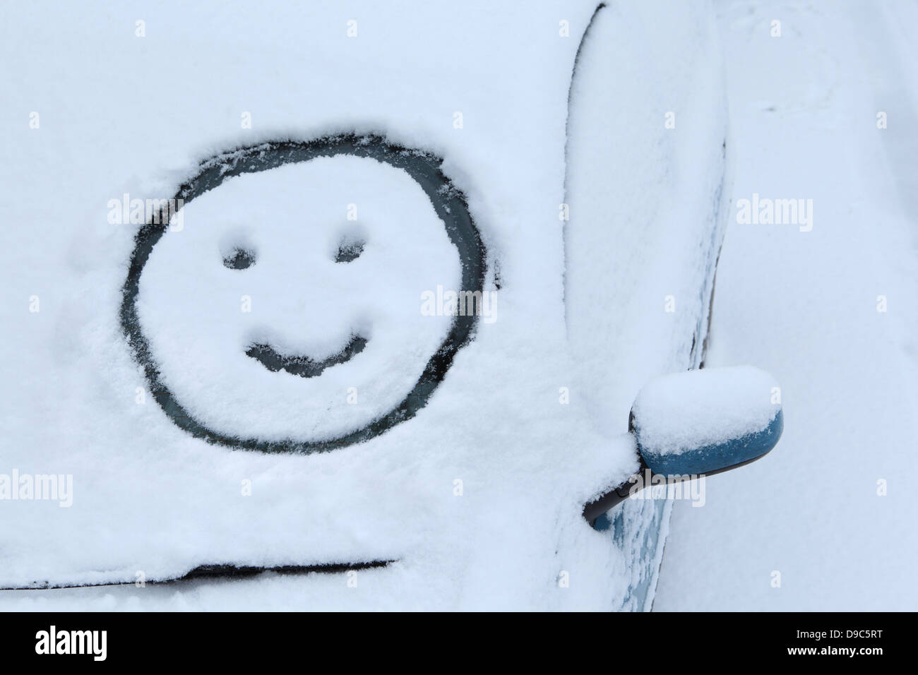 Smiley-Gesicht im Schnee auf dem Auto Windschutzscheibe gezeichnet Stockfoto