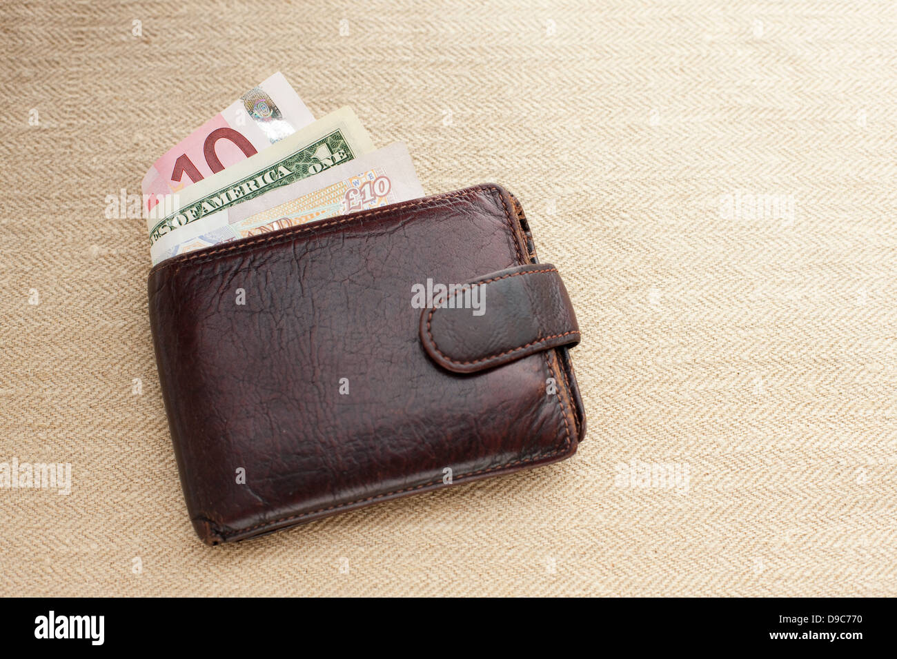 Braune Leder-Portemonnaie mit verschiedenen Währungen Stockfoto