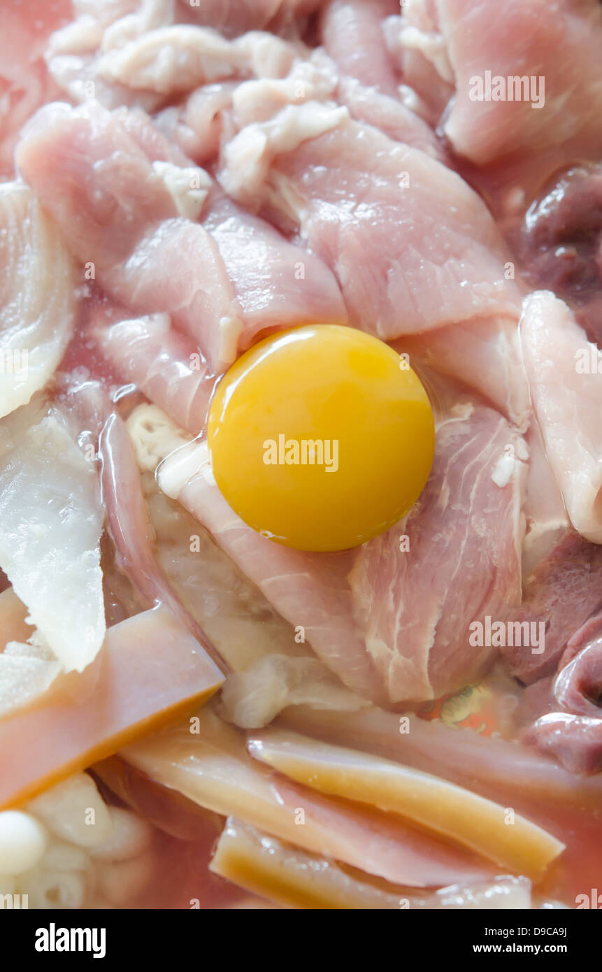 frisch geschnittenes Schweinefleisch, Eigelb Ei bereiten Sie für das Kochen. Stockfoto