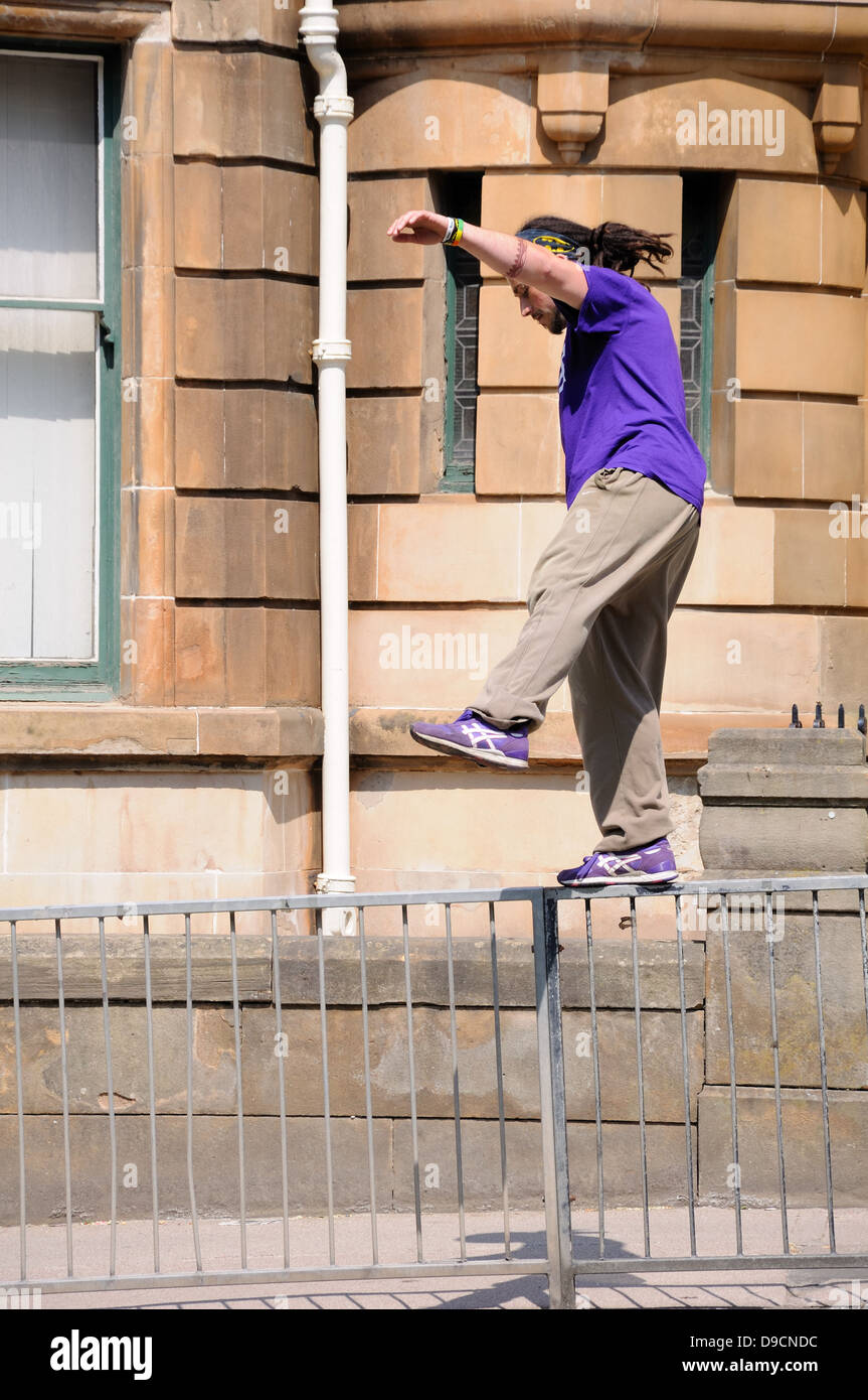 Junger Mann praktiziert Parkour auf einer Straße in Glasgow. Stockfoto